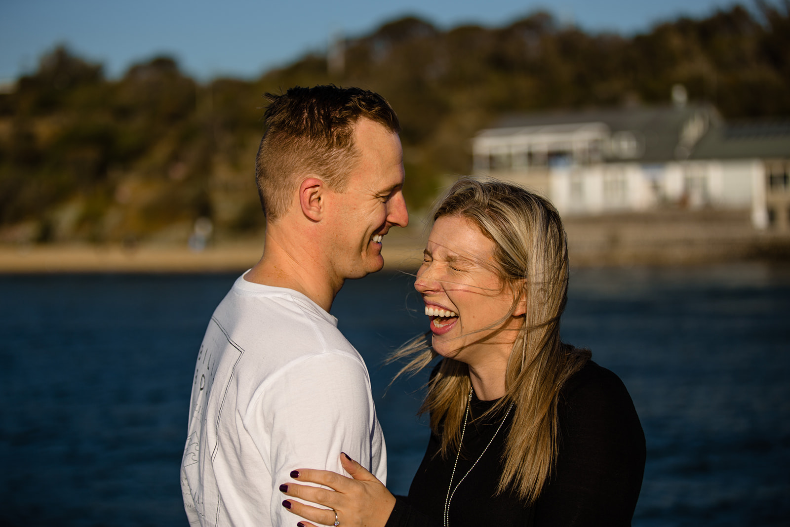 couple laughing on the pier at half moon bay
