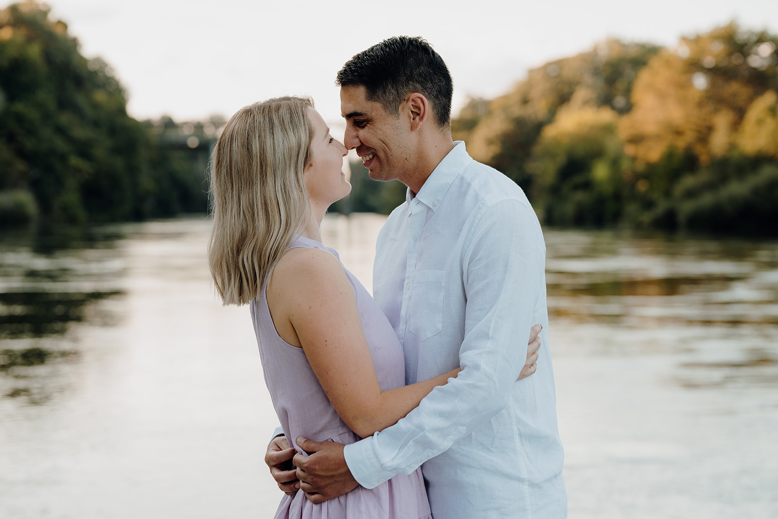A couple walking along the river in Hamilton being photographed during a pre-wedding photoshoot by waikato photographer.