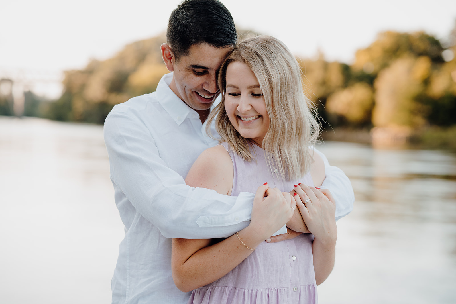 A couple walking along the river in Hamilton being photographed during a pre-wedding photoshoot by waikato photographer.