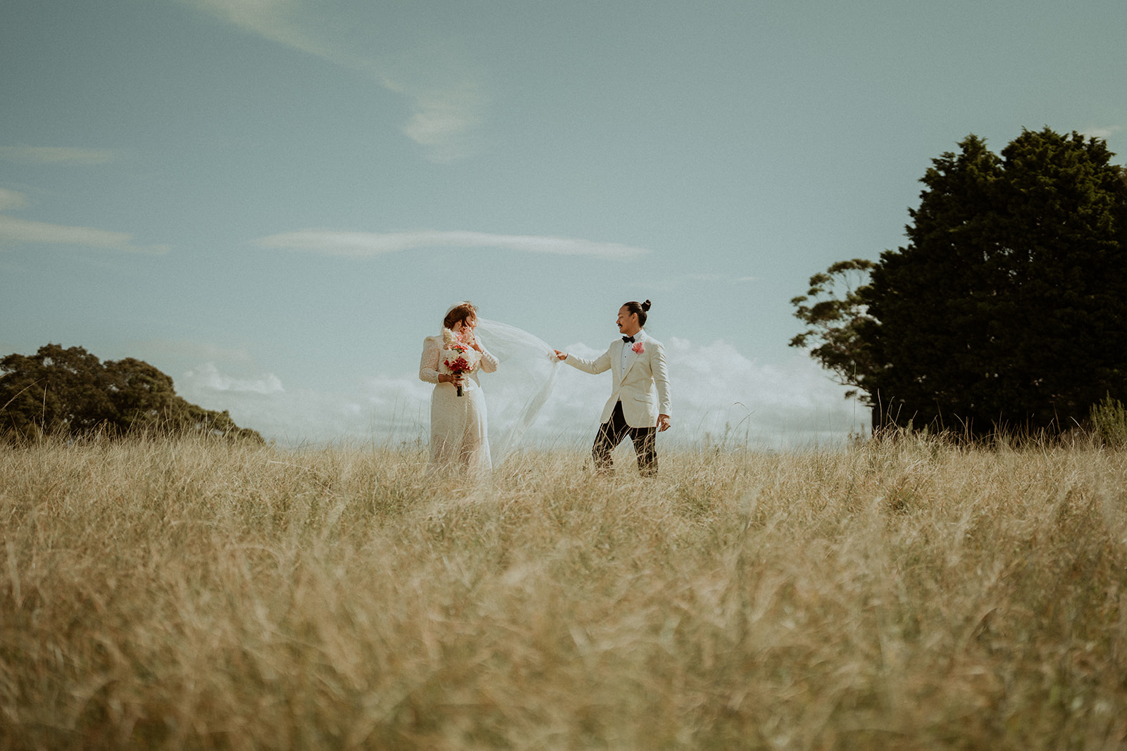 Bride and groom in a field with blue skies at Worrowing Estate