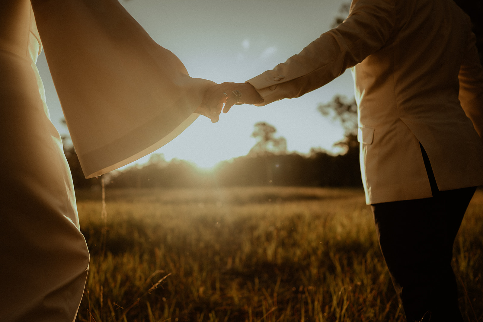 Bride and groom, holding hands at sunset at Worrowing Estate