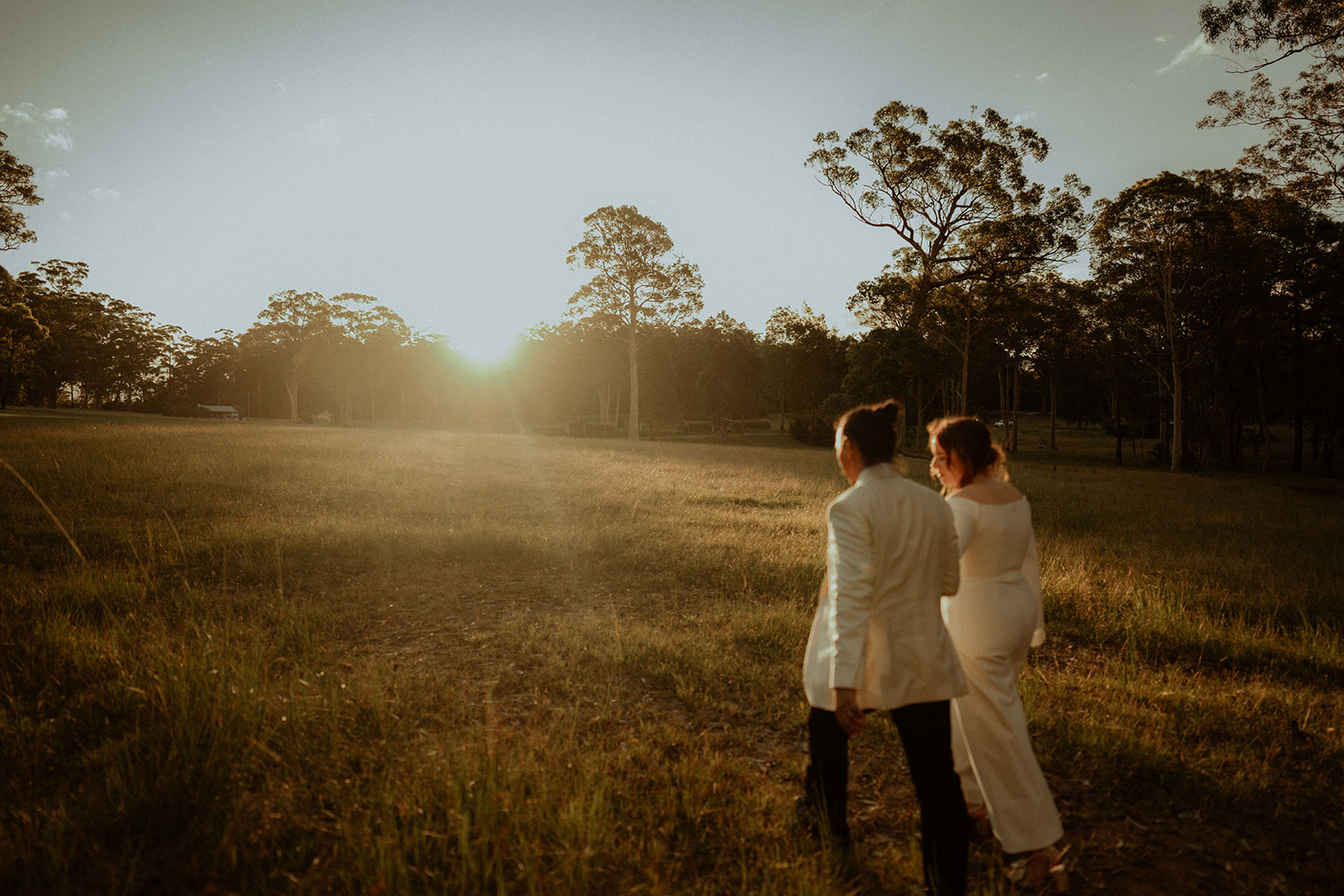 Bride and groom, walking off in the distance at sunset at Worrowing Estate