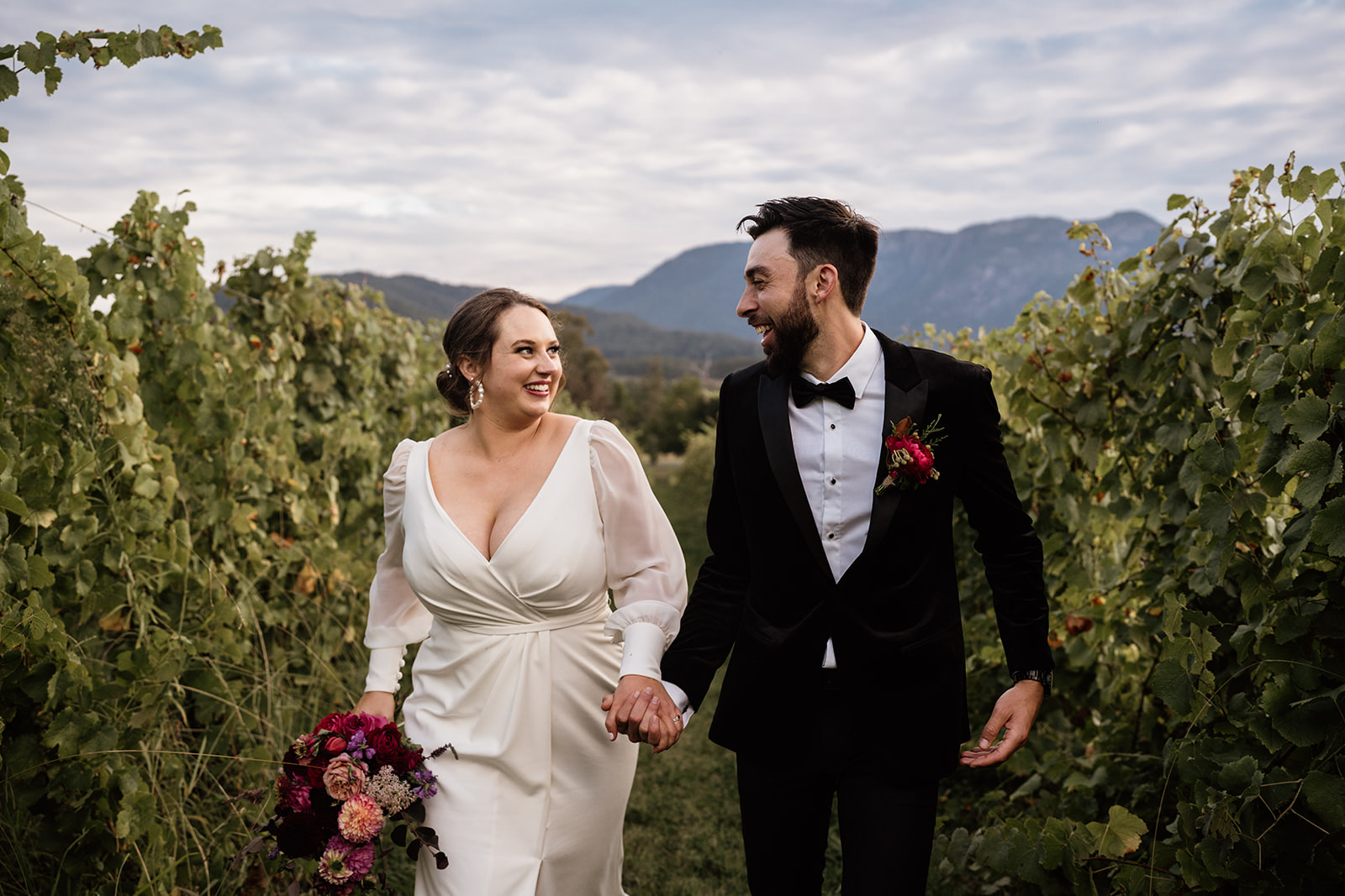 Natural wedding photo at Feathertop Winery in Porepunkah. Bride and groom candid photo in the vineyards at Feathertop.