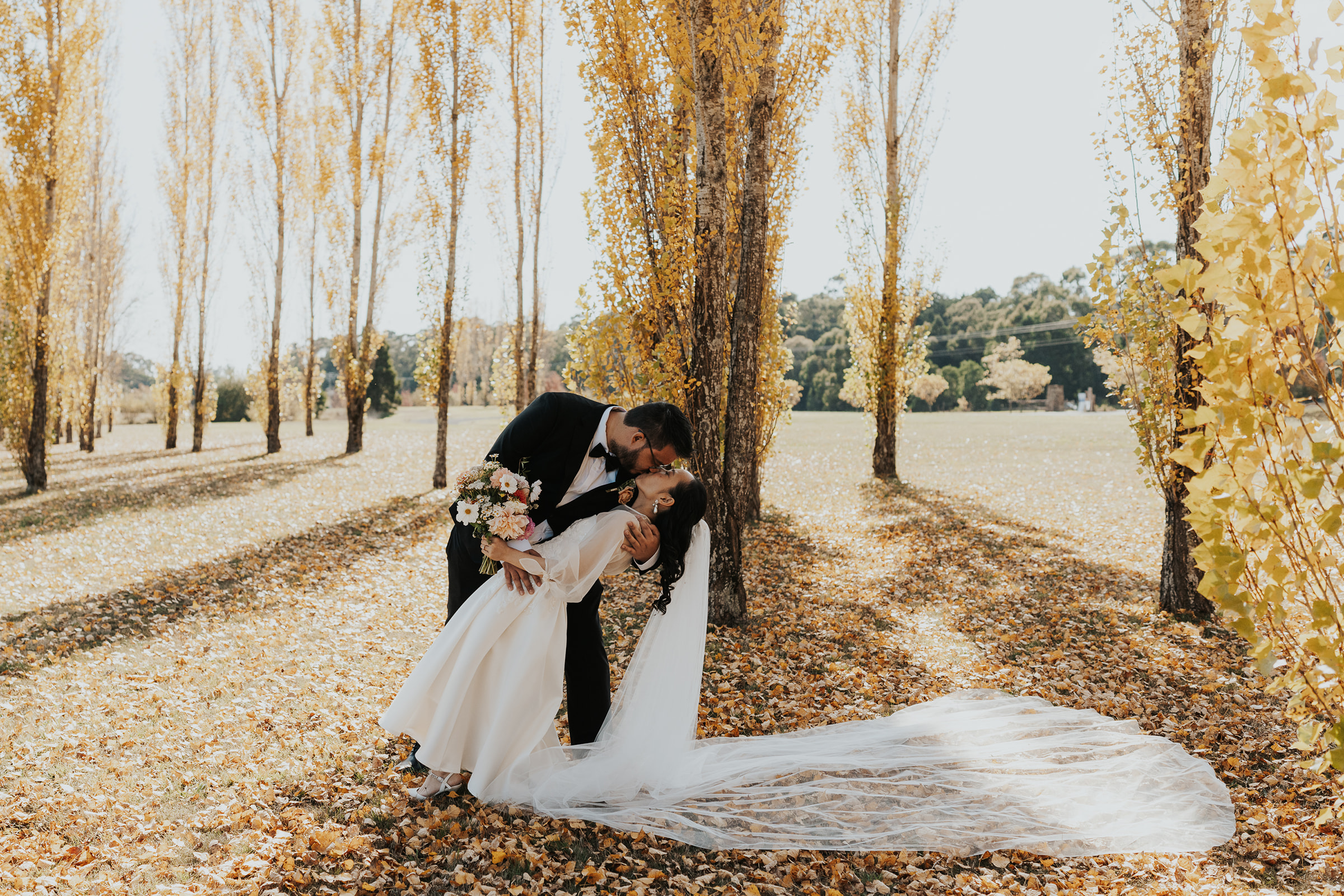 Bride and groom kiss in an autumn field at Sault, Daylesford.