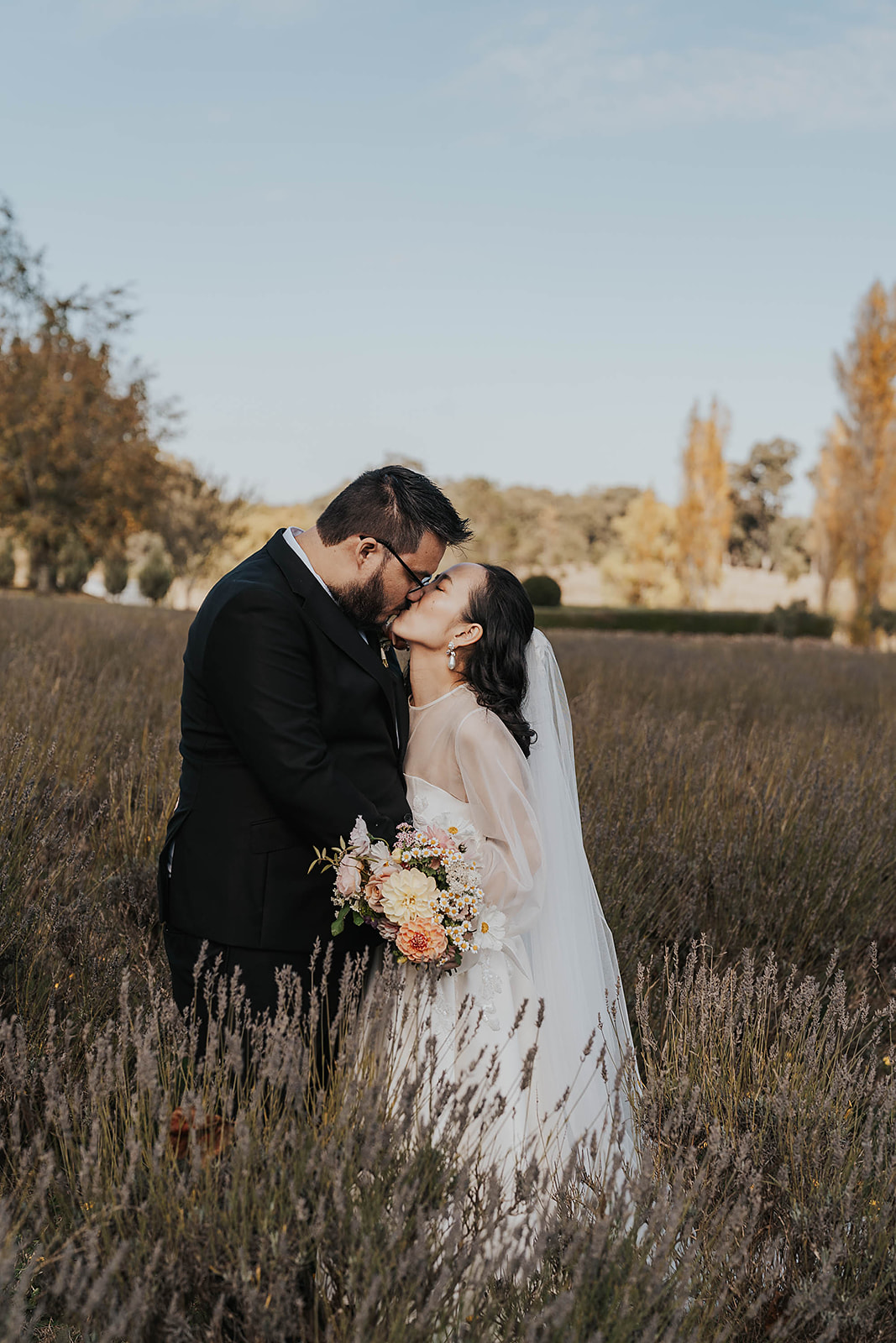 The bride and groom kiss in a lavender field at Sault, Daylesford.