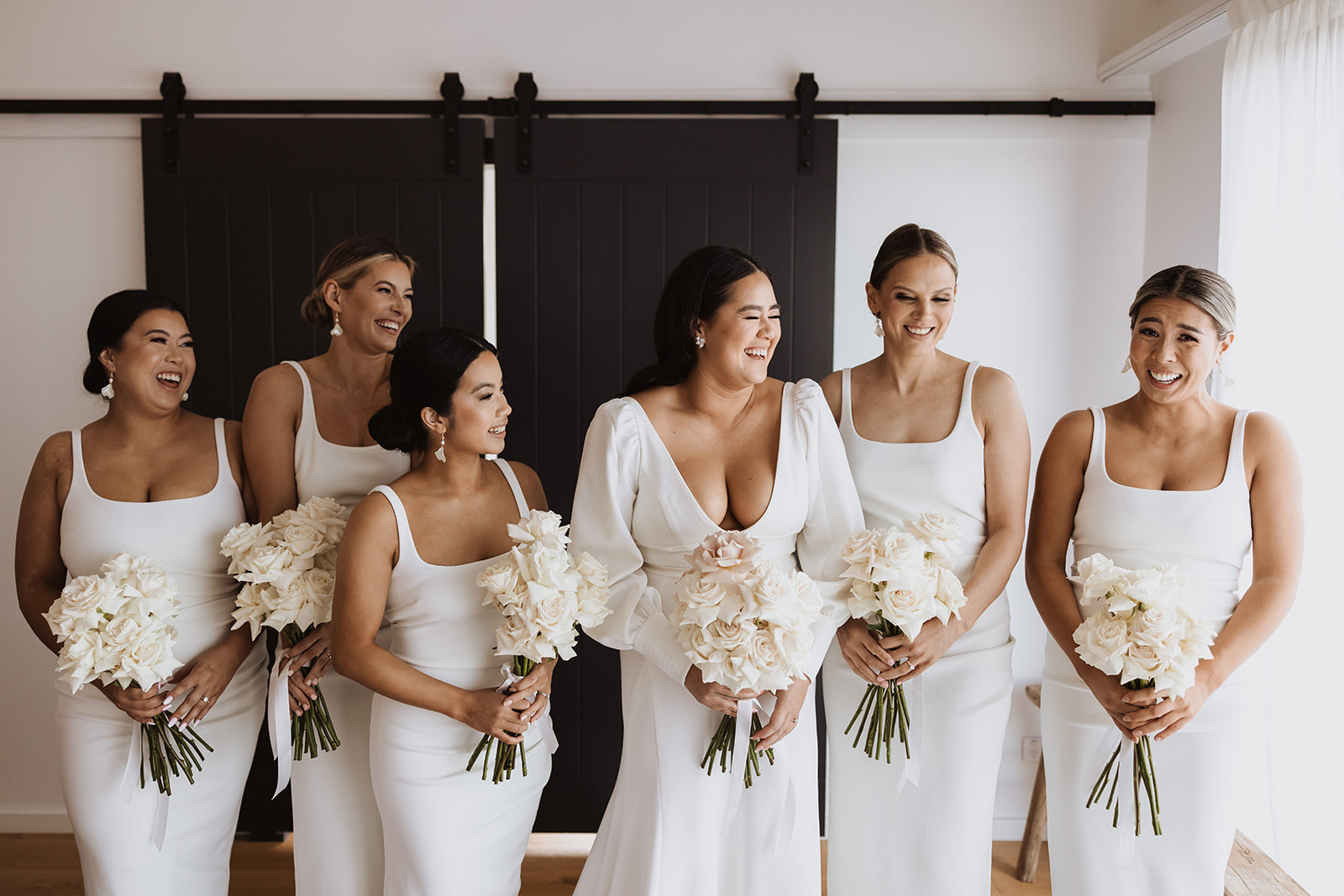 Bride with her bridesmaids wearing gown and holding flower bouquet
