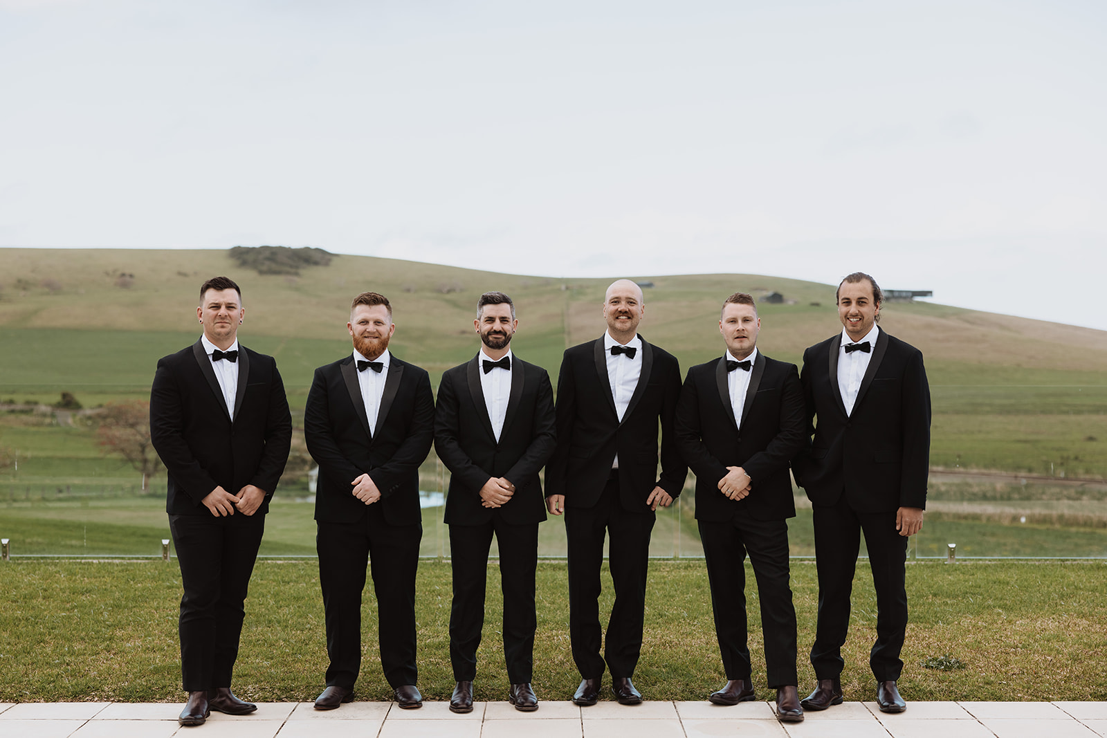 Groom together with his groomsmen wearing black suits