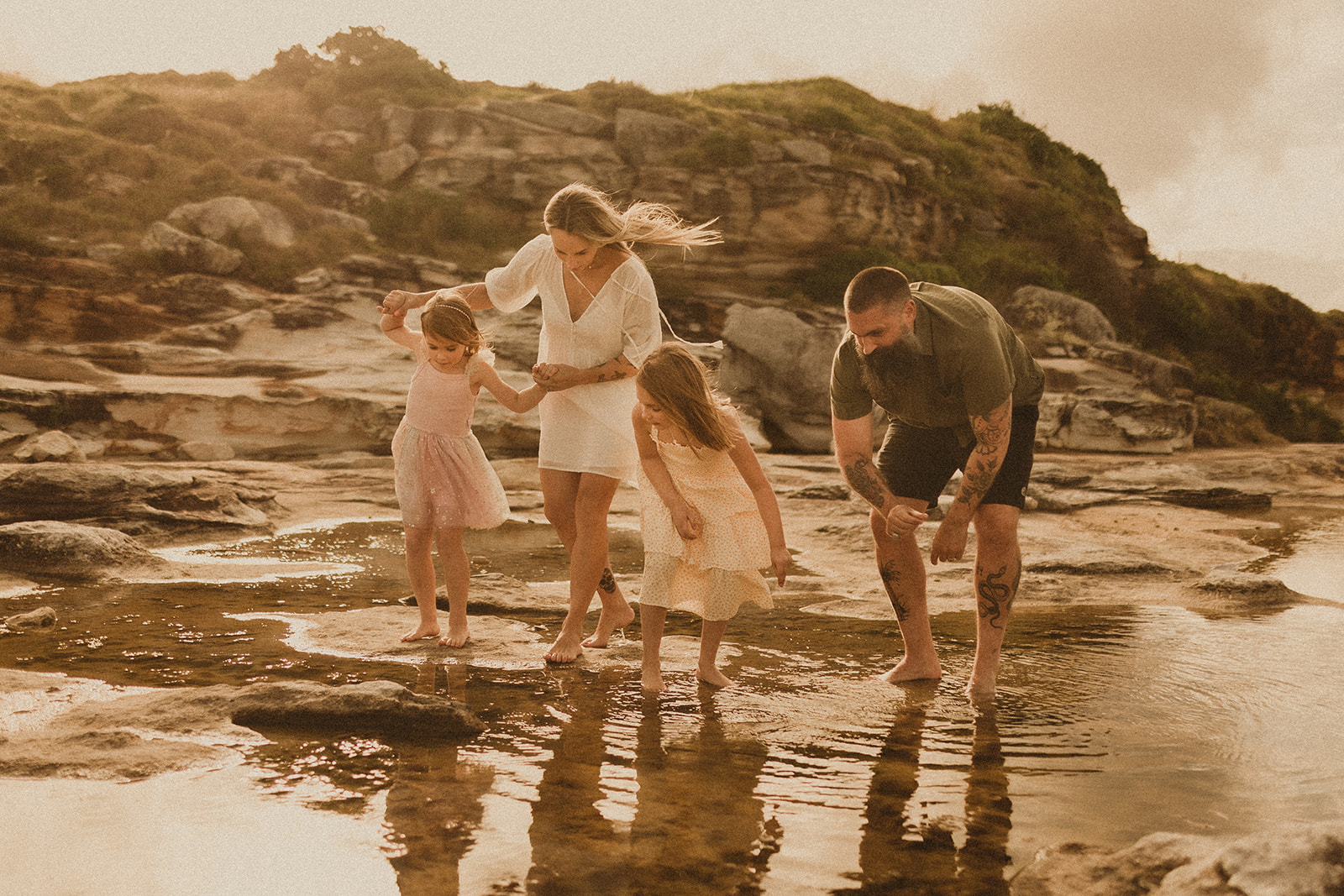 Family looking at the puddles while rock climbing. Family photography Sydney Eastern suburbs