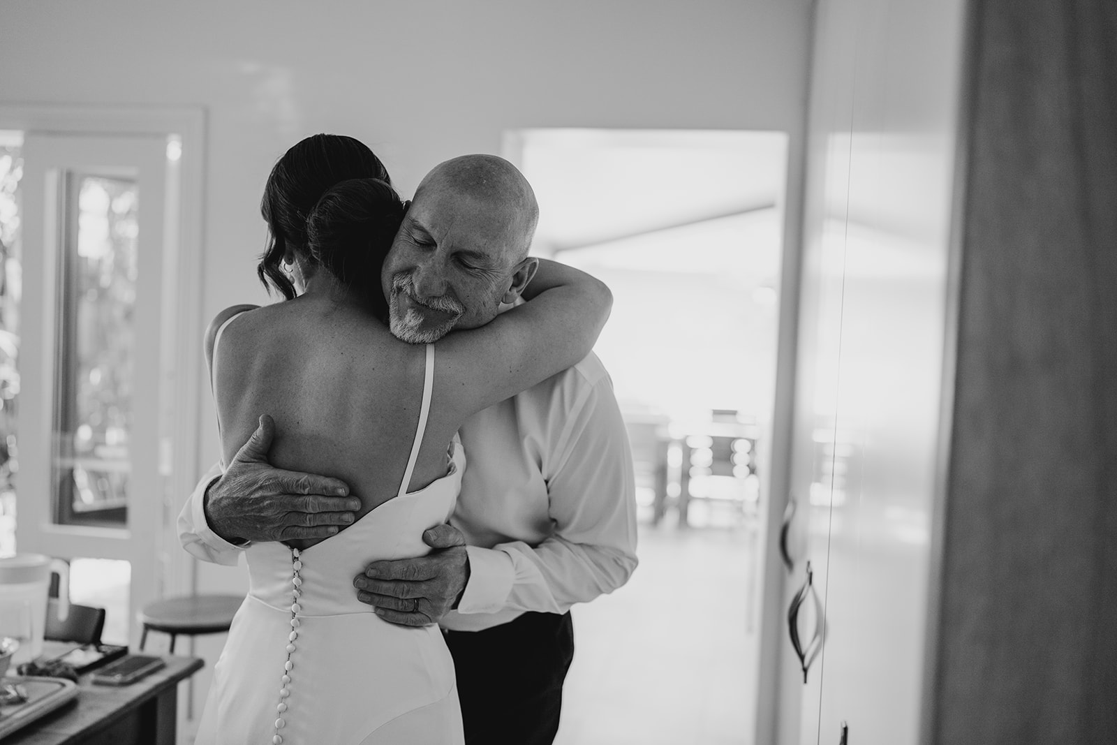 Bride and father of the bride share a emotional hug whilst cinematic wedding photographer capture the moment
