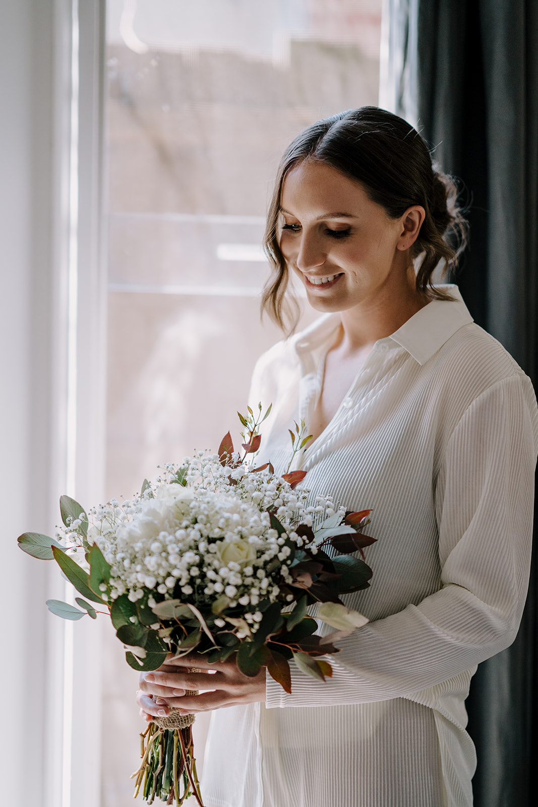 Bride gazing at her bouquet before getting ready