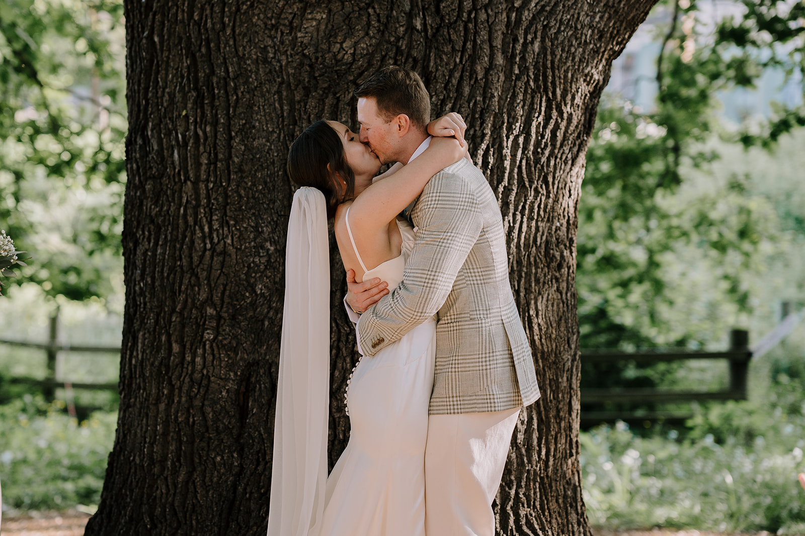 Bride and groom share a kiss by the Oak tree in Collingwood wedding inspiration