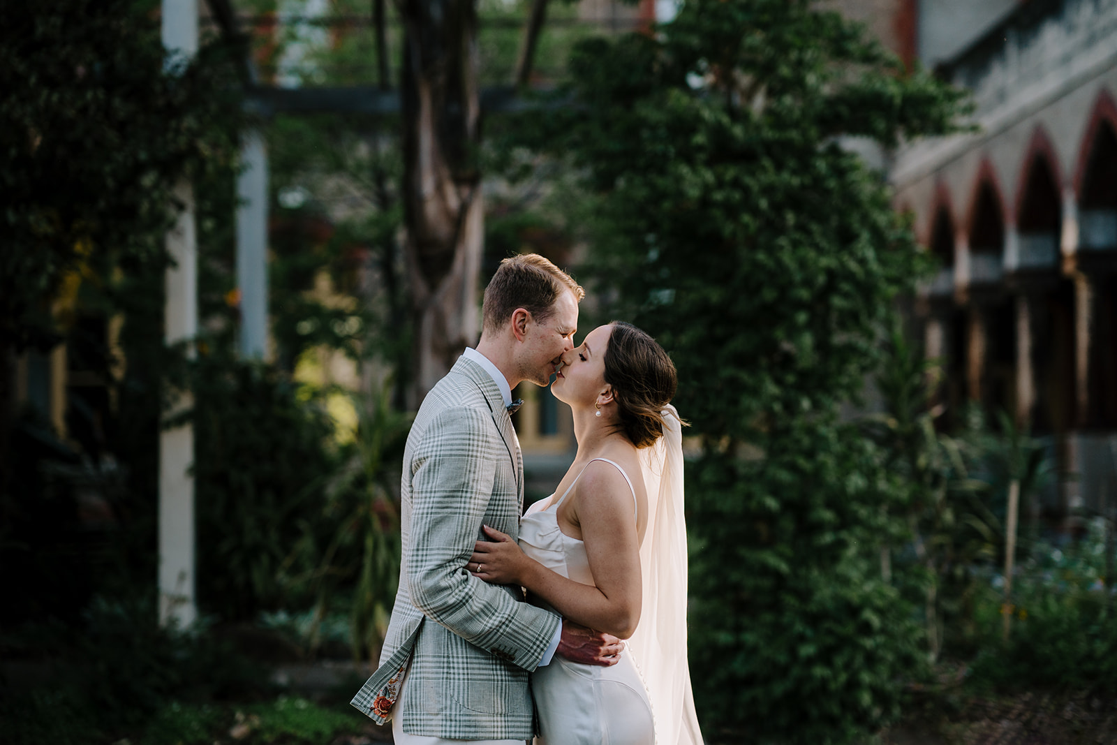 Documentary wedding photographer in Melbourne captures bride and groom sharing a kiss together in Abbotsford Convent