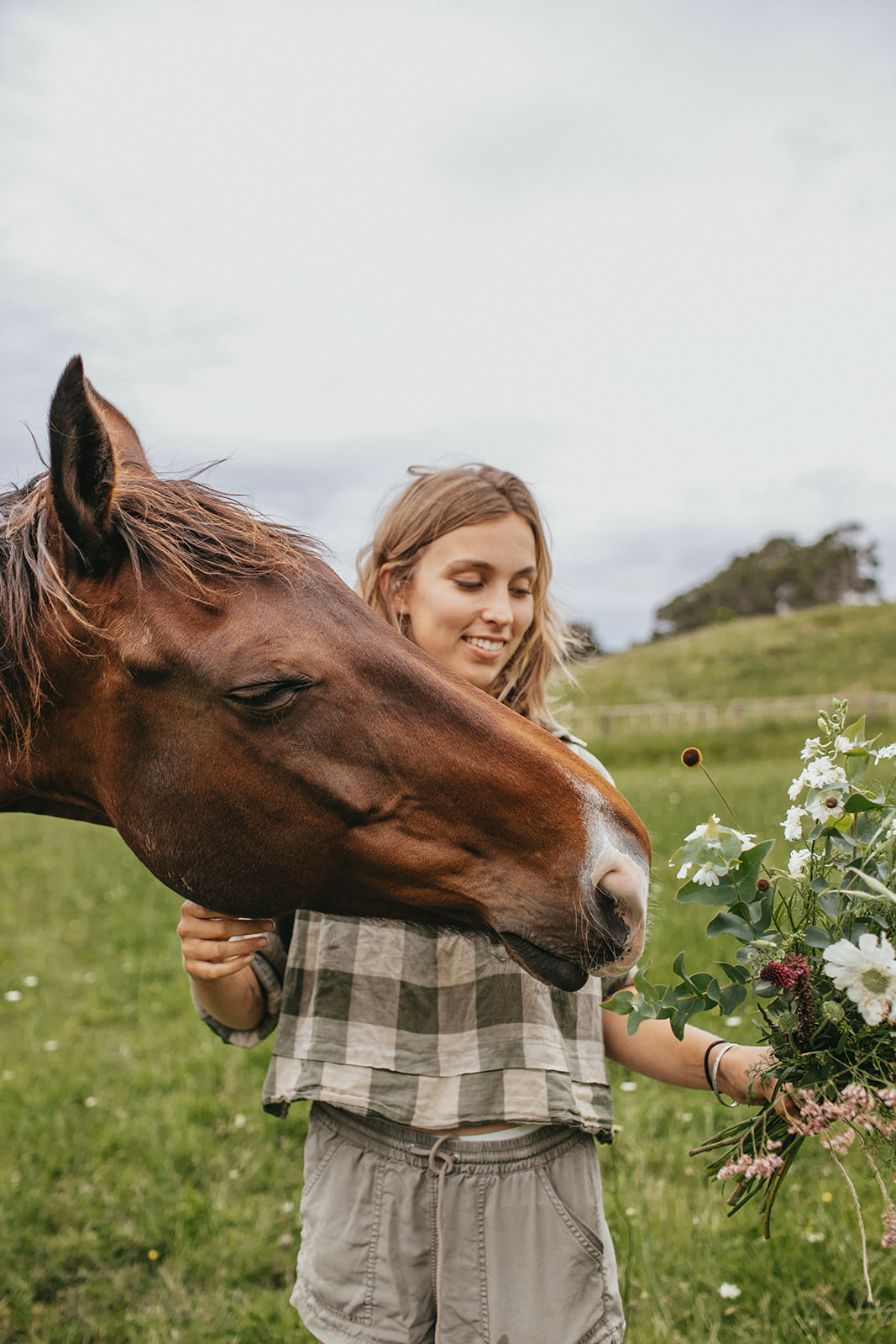 Sustainable flower farmer with her horse, and a bouquet.