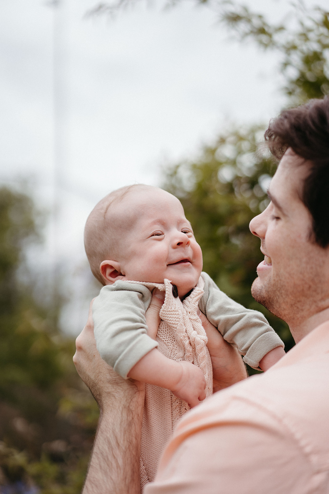 a baby with a disability smiles at his father