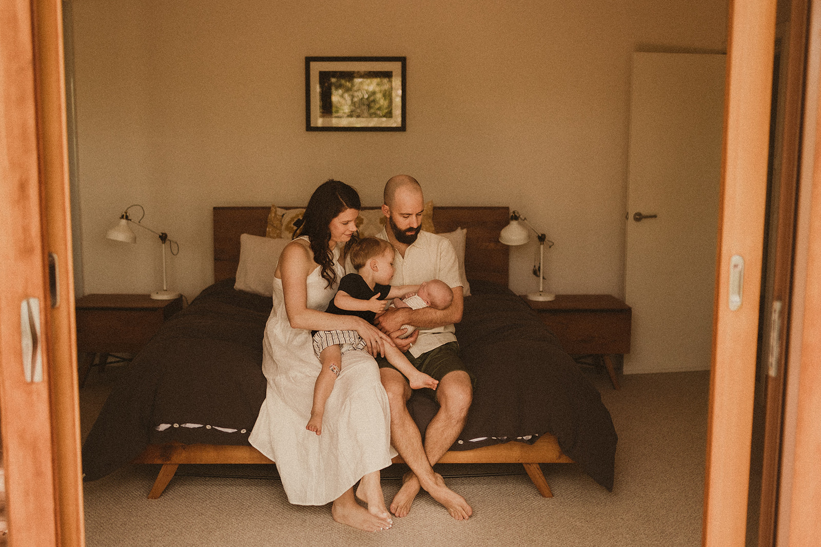 Sydney Family welcome newborn baby into their family at home, snuggling on the bed with their two year old son