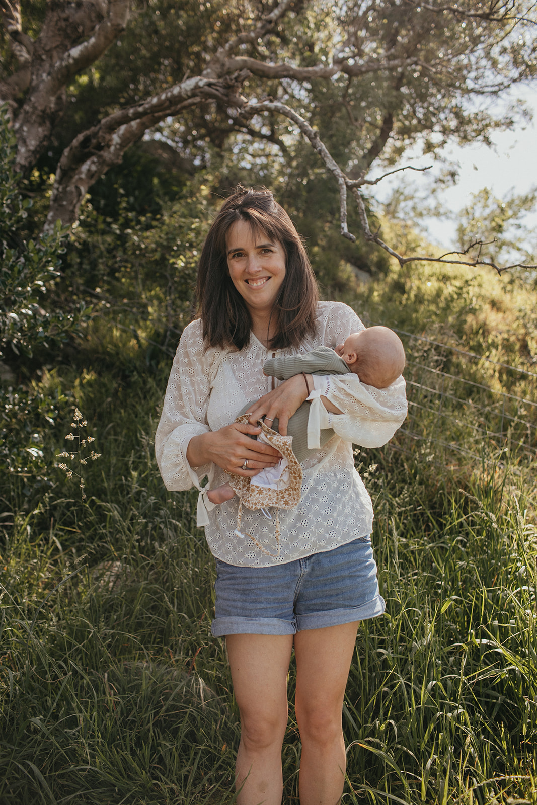 Mother holding newborn son in garden in Christchurch