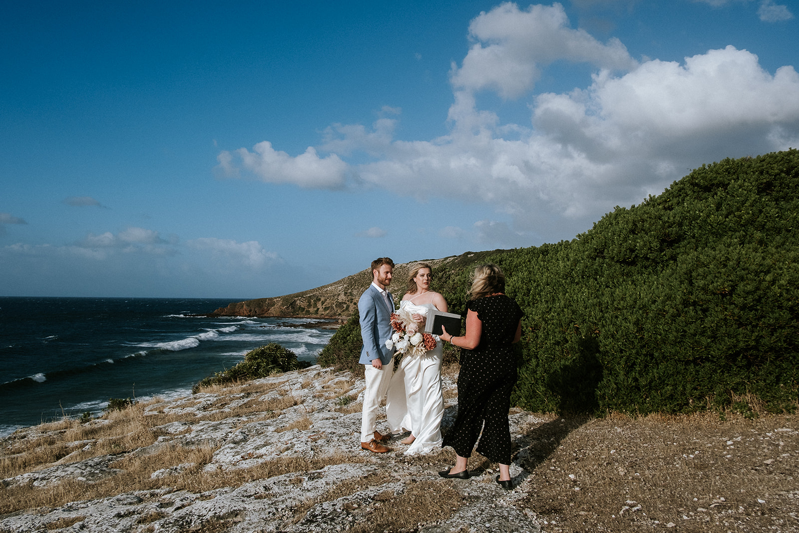 Katie and Josh exchanging the vows on a clifftop overlooking Stoked Bay during their elopement on Kangaroo Island