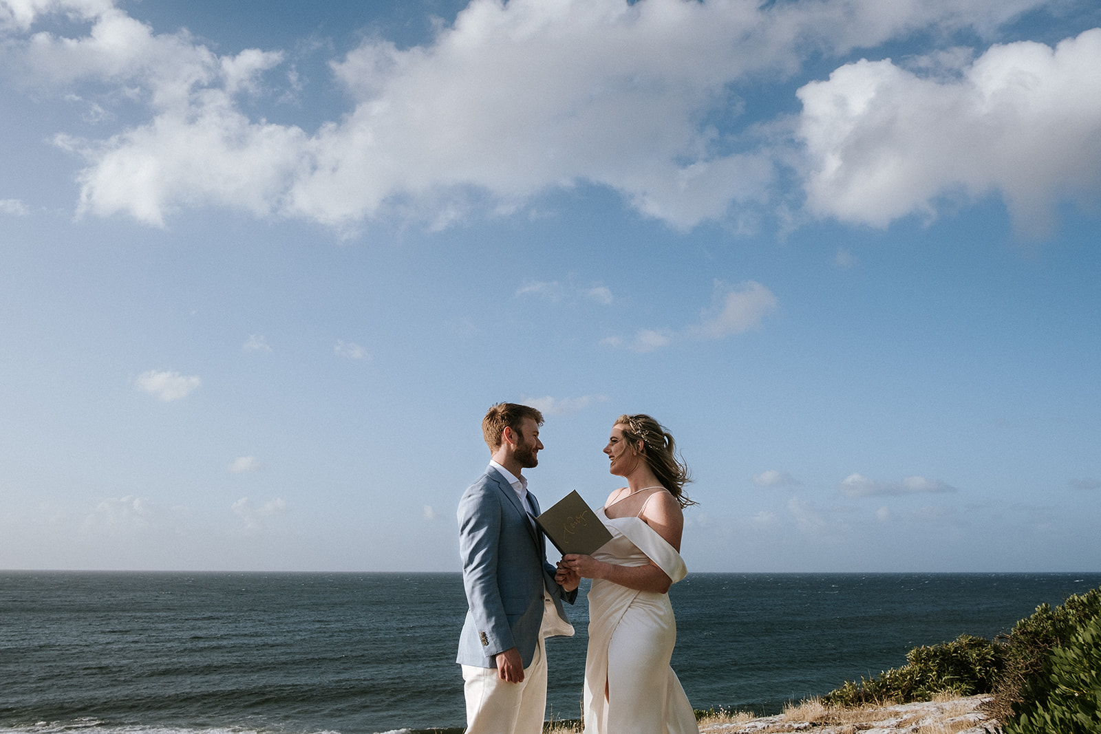 Katie and Josh exchanging the vows on a clifftop overlooking Stoked Bay during their elopement on Kangaroo Island