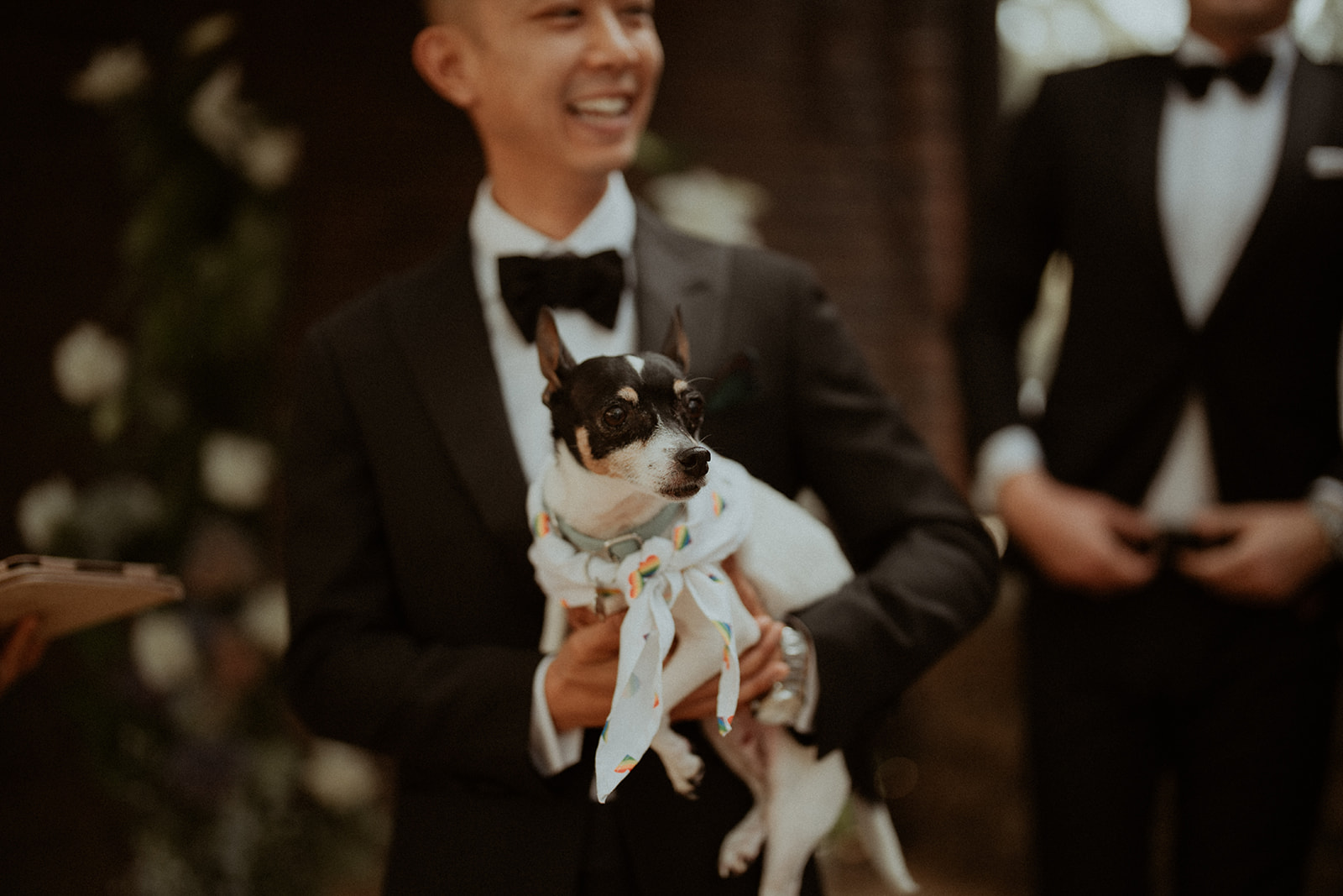 Groom at the ceremony, holding his little dog