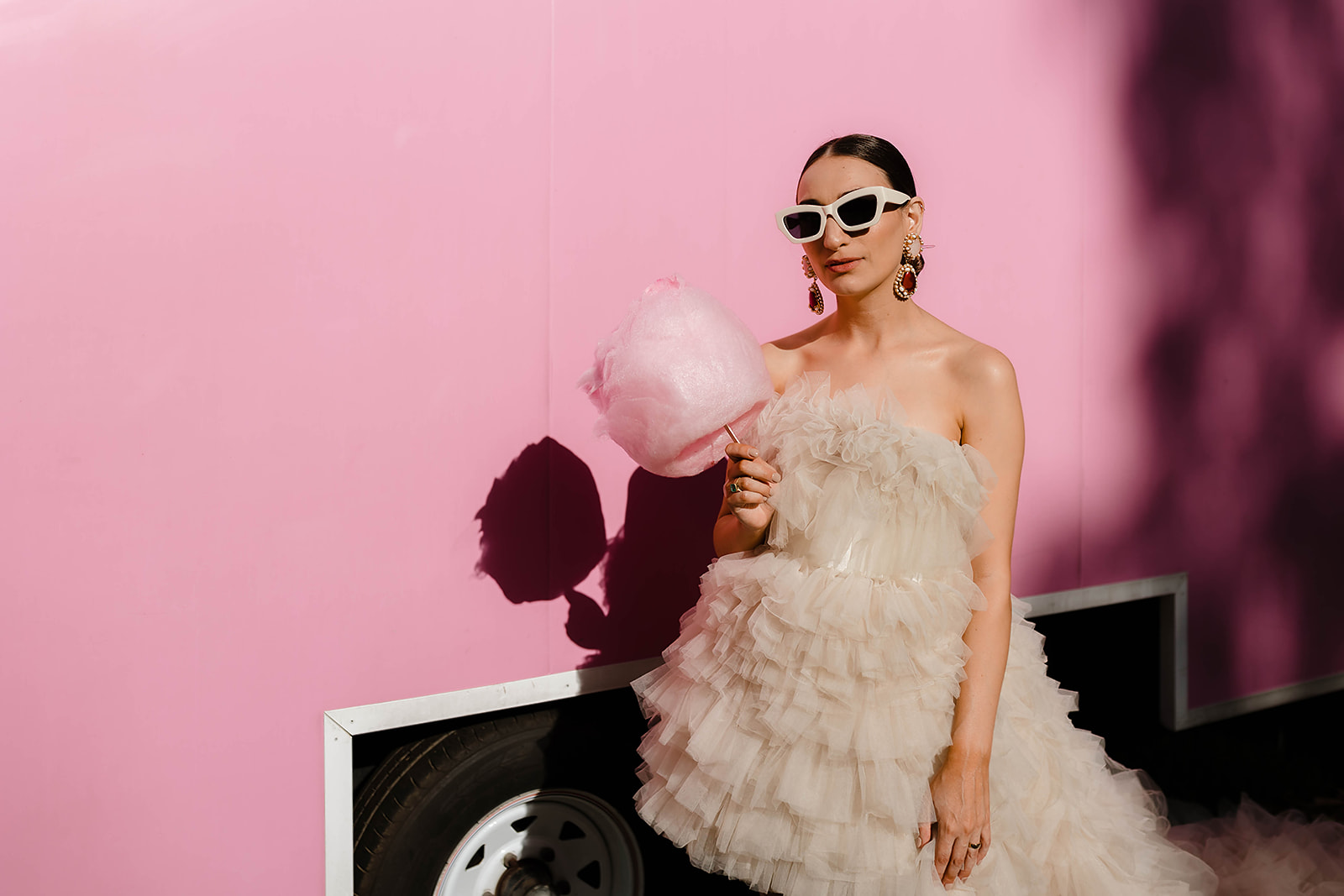 A bride holding a pink cotton candy and wearing sunglasses in Adelaide wedding