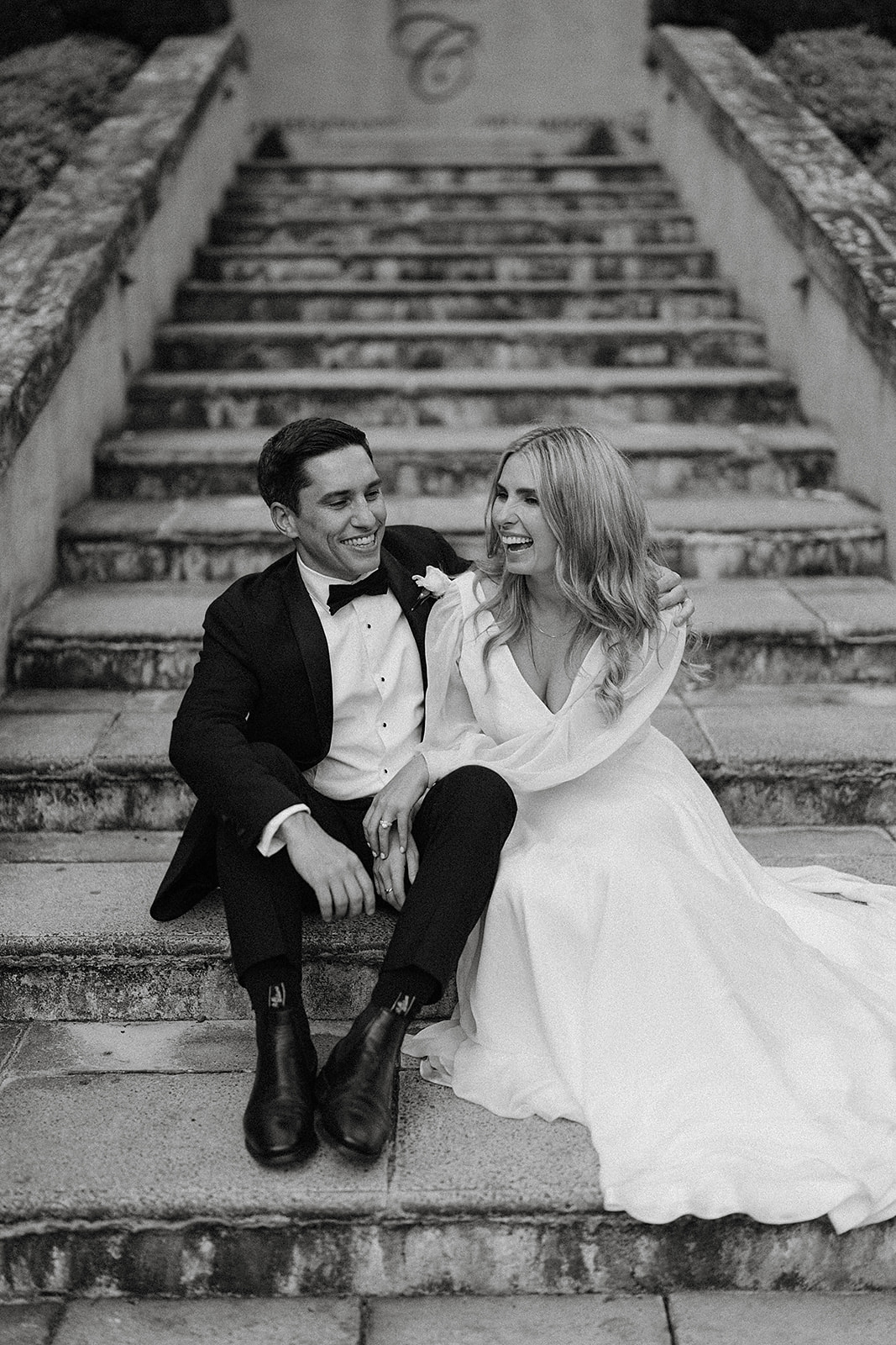 Grace and Tom sitting on the front stairs at their Centennial Vineyards wedding
