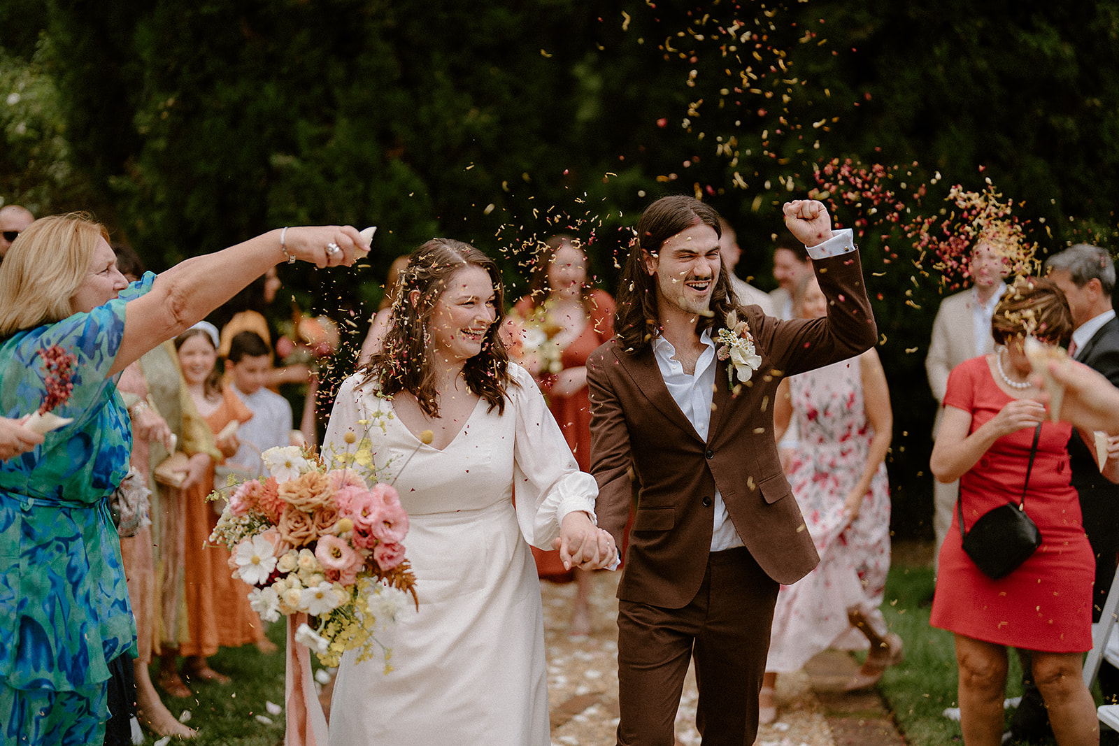 An epic couple walking down the aisle, showered in confetti at their Fitzroy Inn wedding.