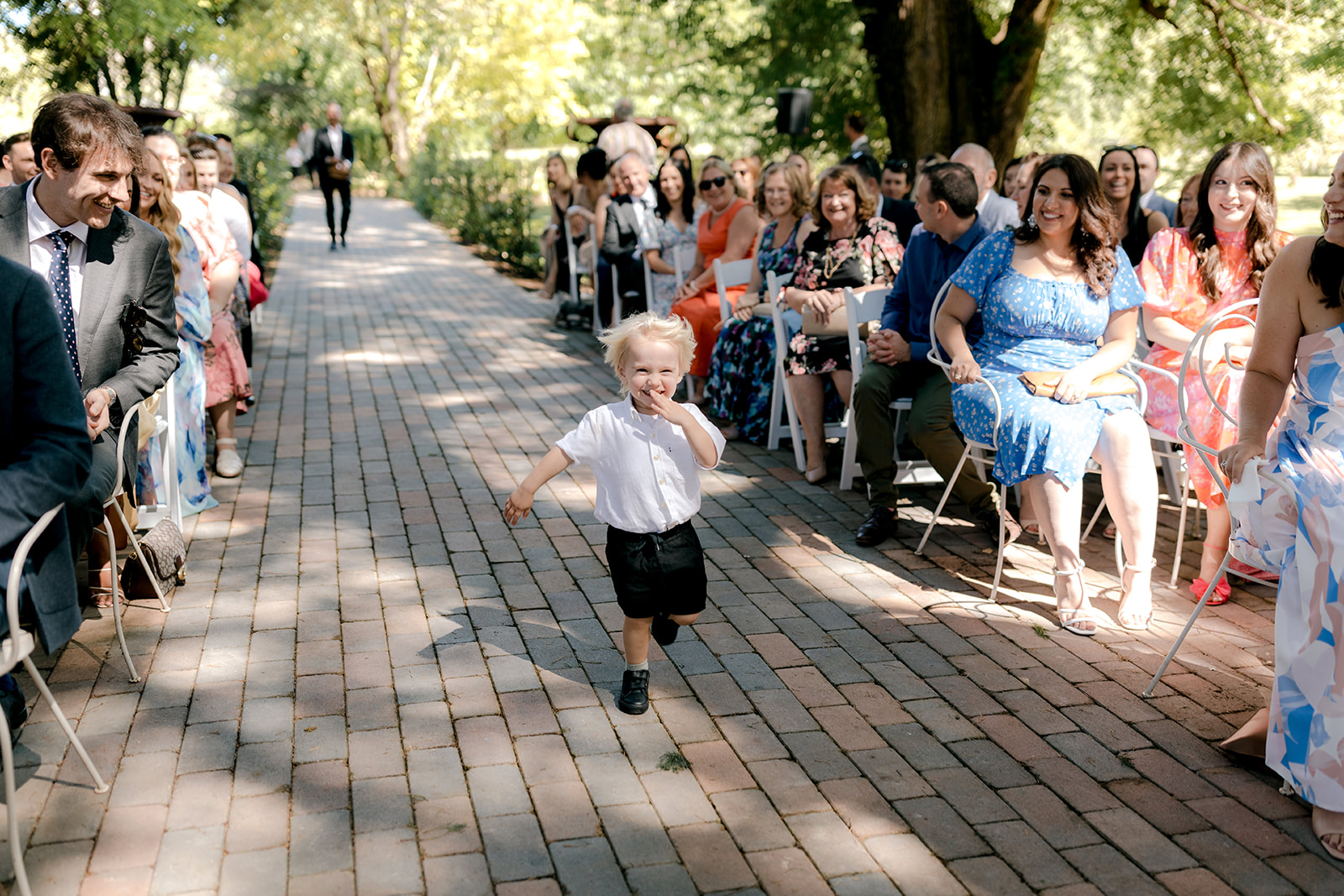 Ring bearer walking down the aisle at an elegant country wedding.