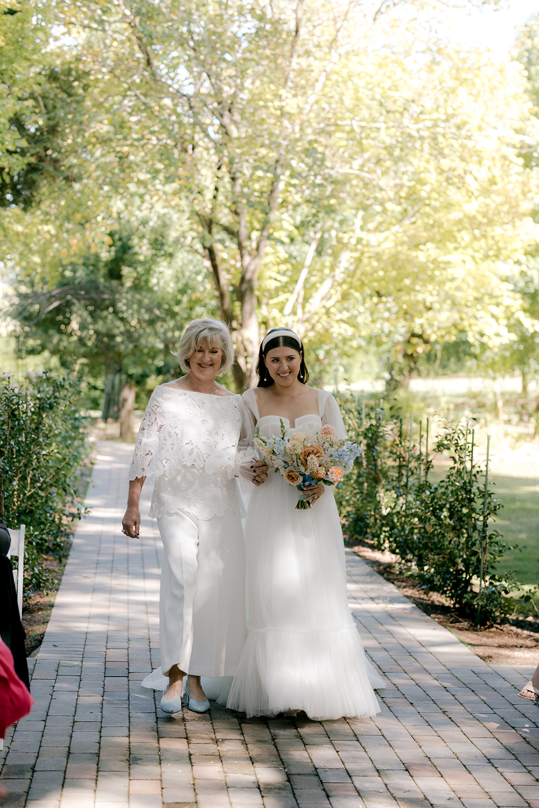 Bride & mother of the bride walking down the aisle at her elegant country wedding.
