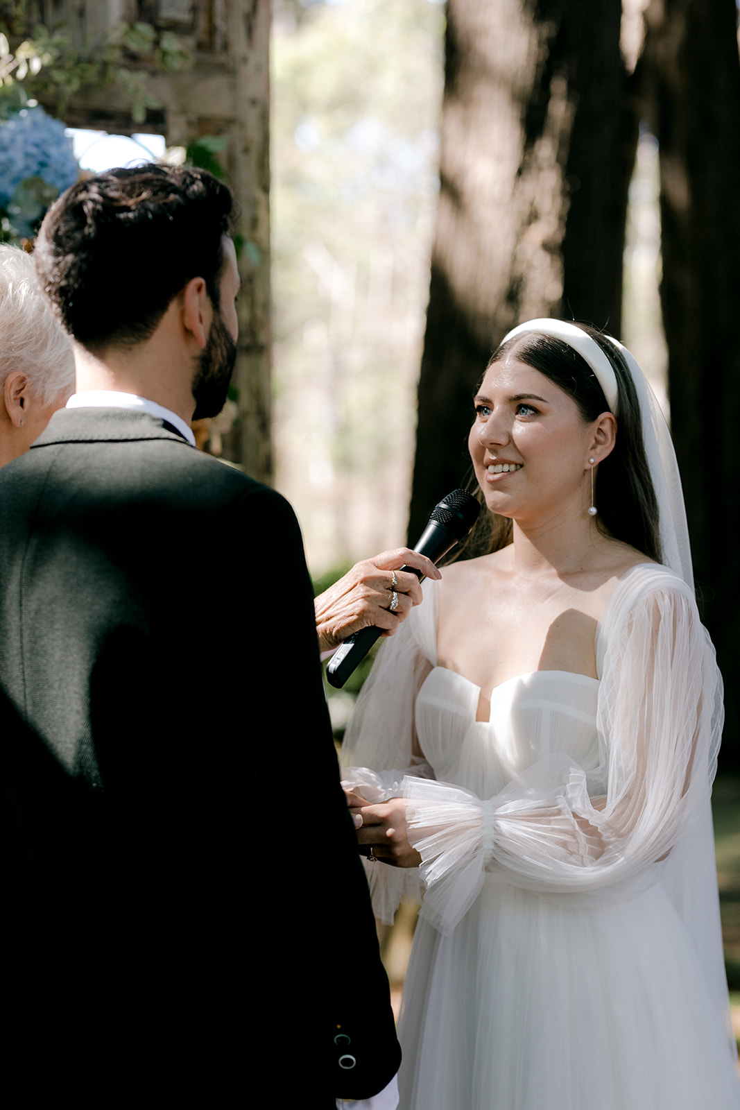 Portrait of bride & groom exchanging rings at their elegant country wedding ceremony.