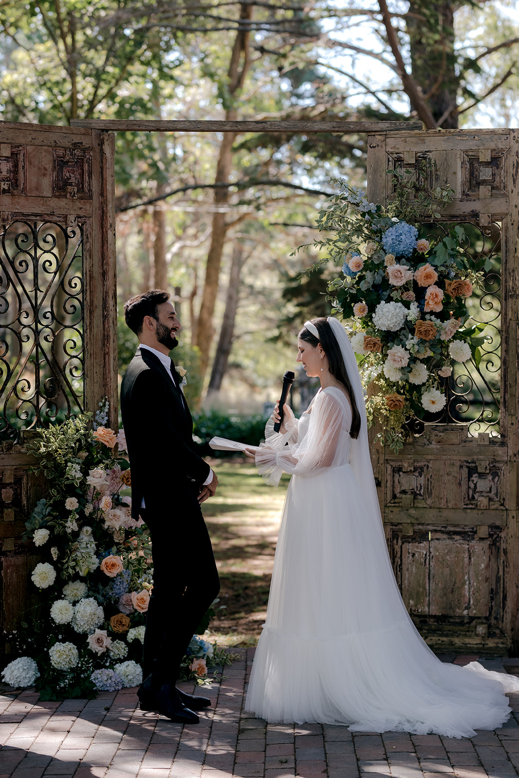 Portrait of bride & groom exchanging vows at their elegant country wedding ceremony.
