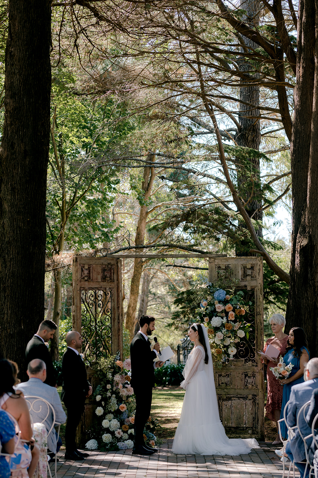 Portrait of bride & groom exchanging vows at their elegant country wedding ceremony.