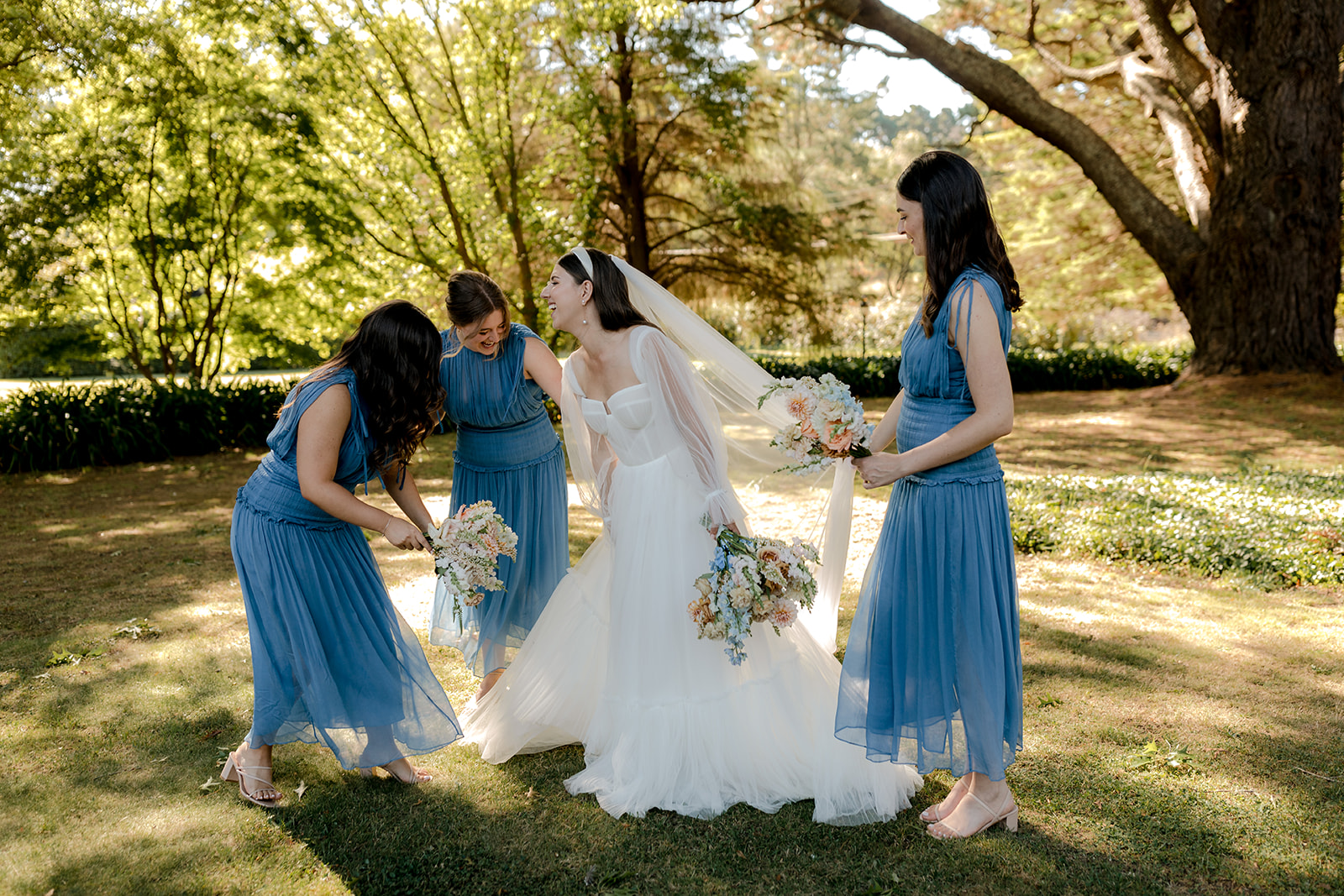 Bride with her bridesmaids holding their bridal bouquets at her elegant country wedding.