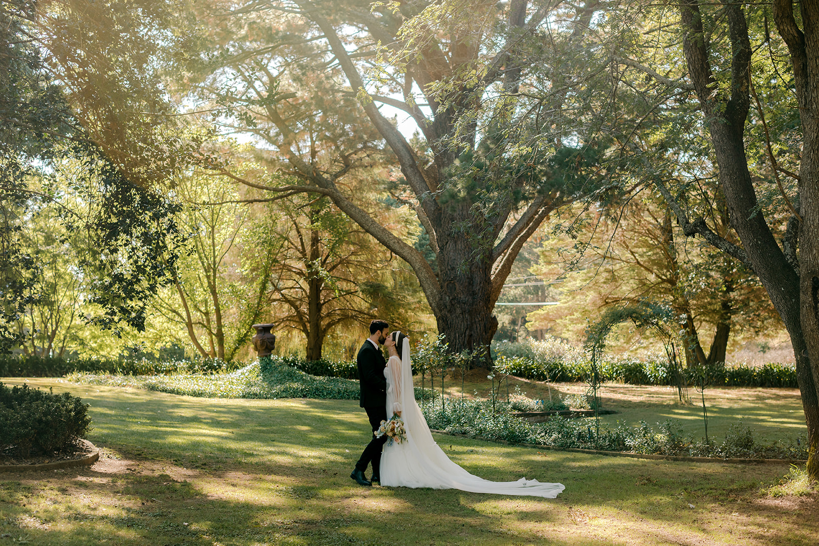 Portrait of bride & groom in an English-inspired garden during their elegant country wedding.