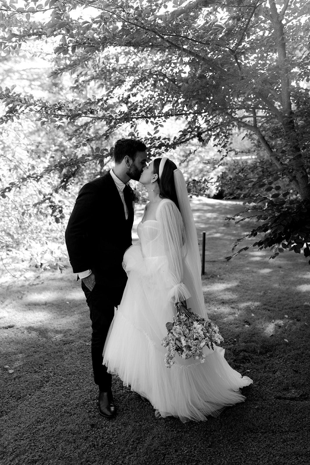 Portrait of bride & groom in an English-inspired garden during their elegant country wedding.