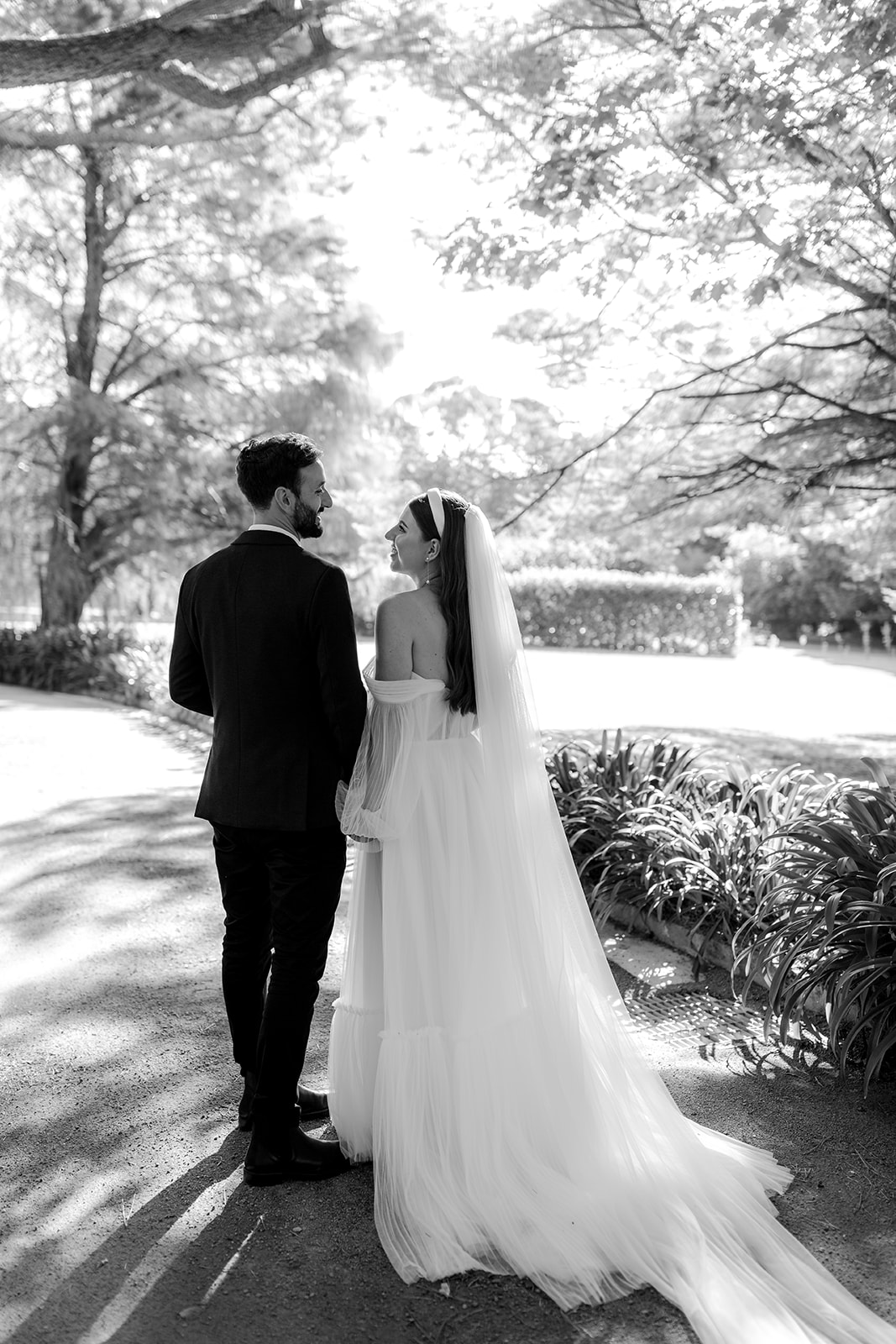 Portrait of bride & groom walking in an English-inspired garden during their elegant country wedding.