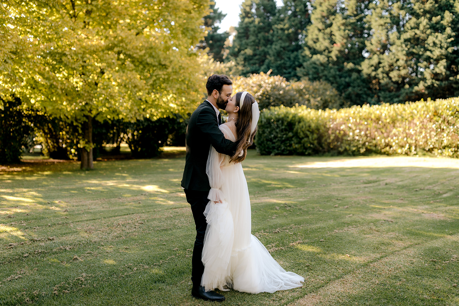 Portrait of bride & groom dancing in an English-inspired garden during their elegant country wedding.