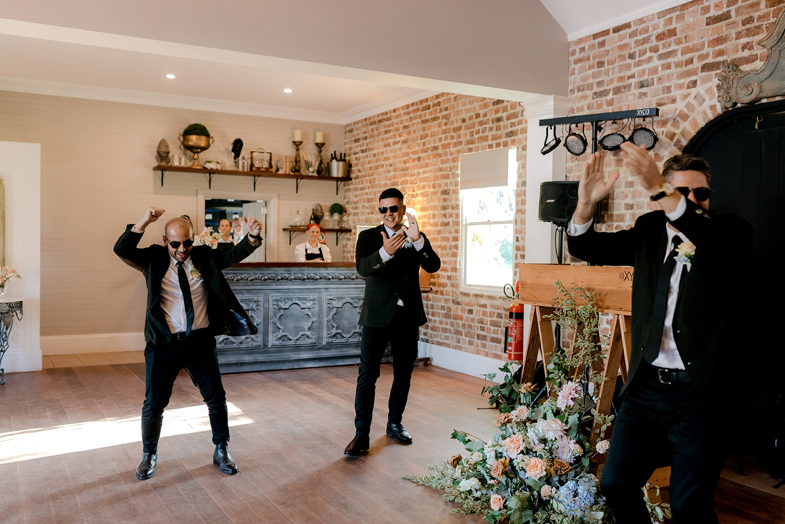 Groomsmen making a fun entrance at an elegant country wedding reception.
