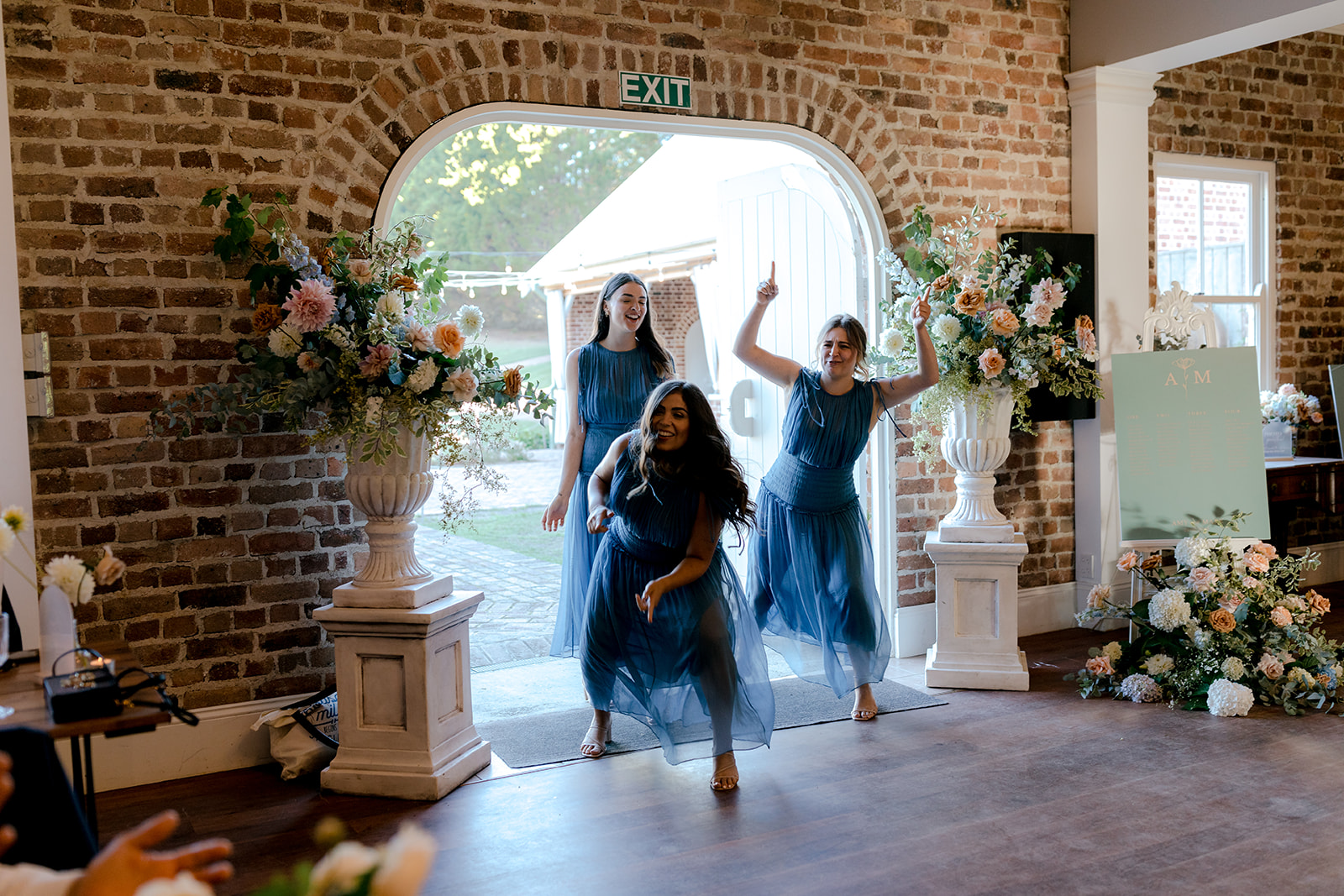 Bridesmaids making a fun entrance at an elegant country wedding reception.
