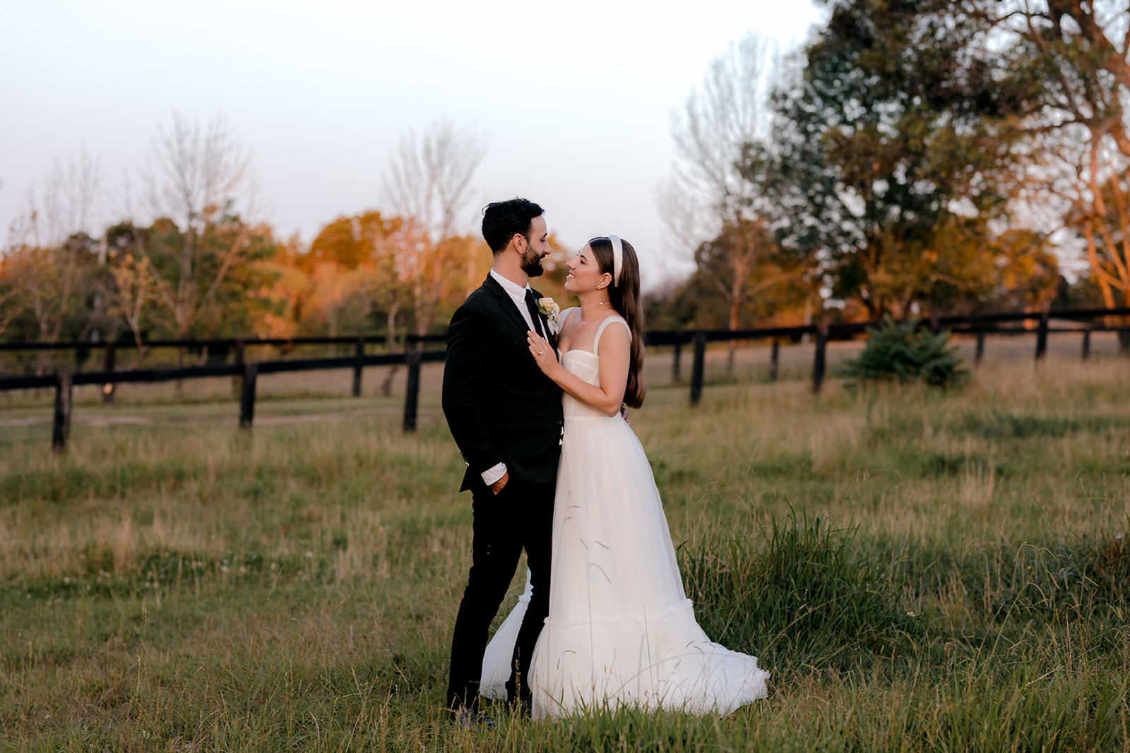 Portrait of bride & groom at sunset during their elegant country wedding.