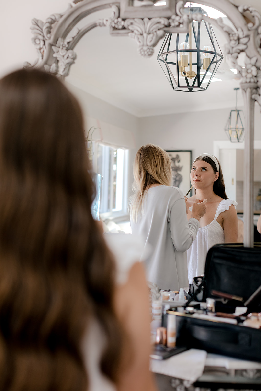 Bride getting her make-up done for her elegant country wedding.