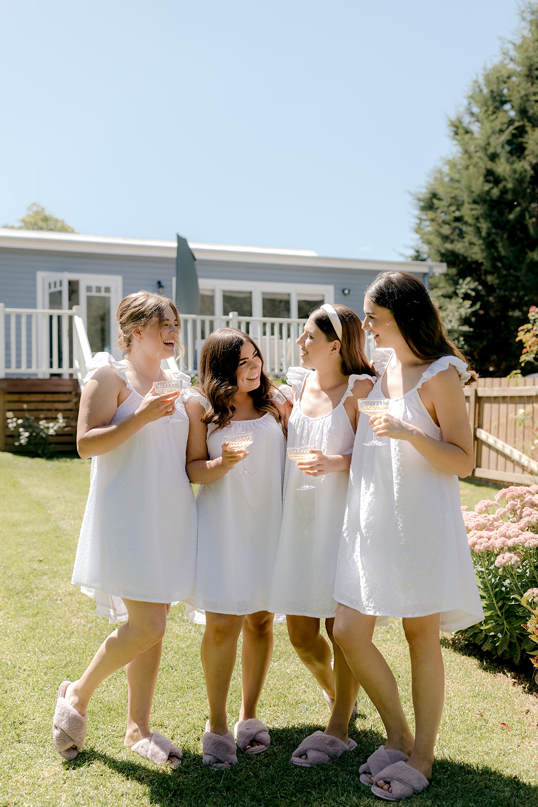Bridesmaids popping champagne whilst getting ready for an elegant country wedding.