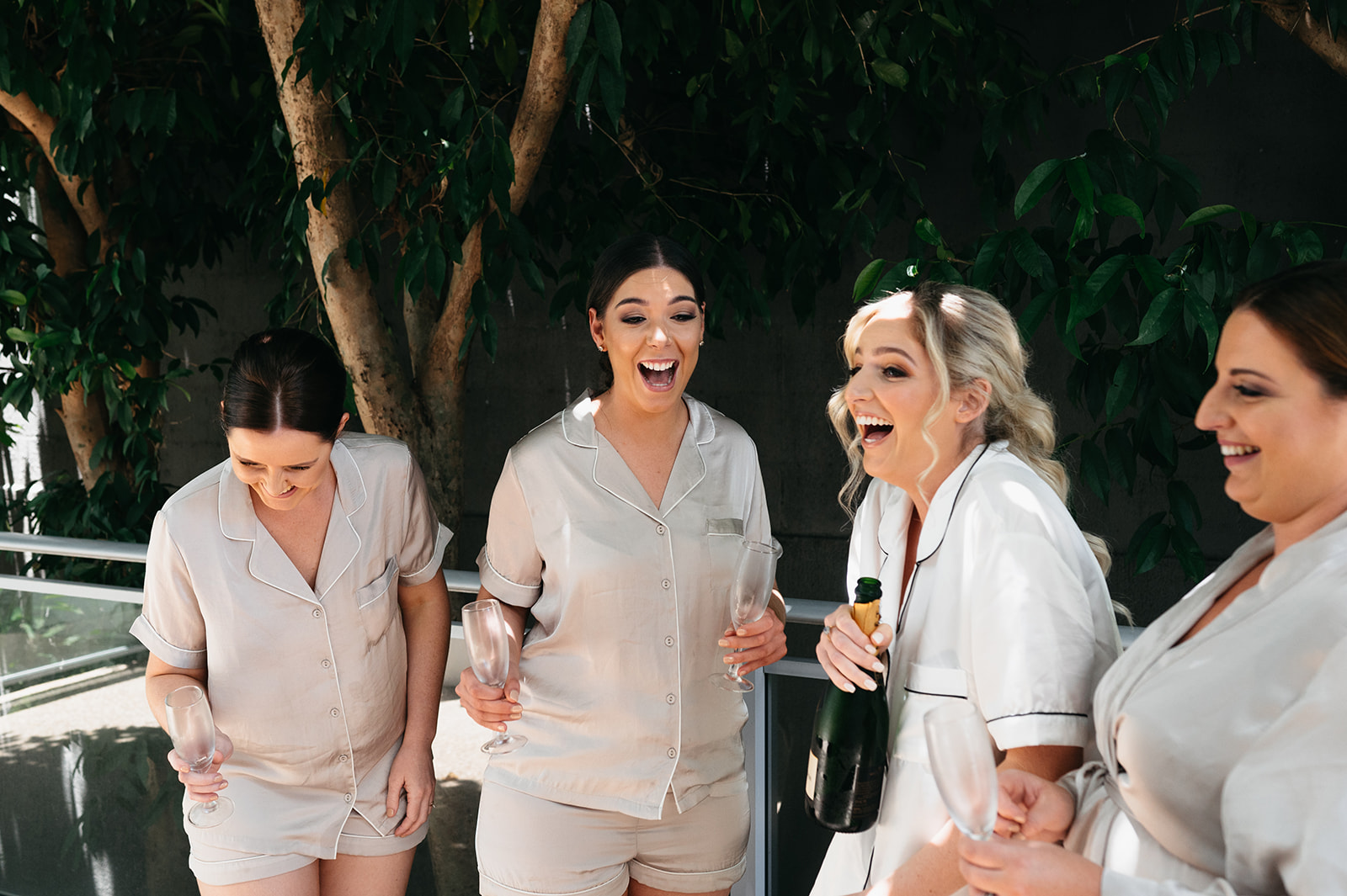 bride and bridesmaids popping champagne in Cairns