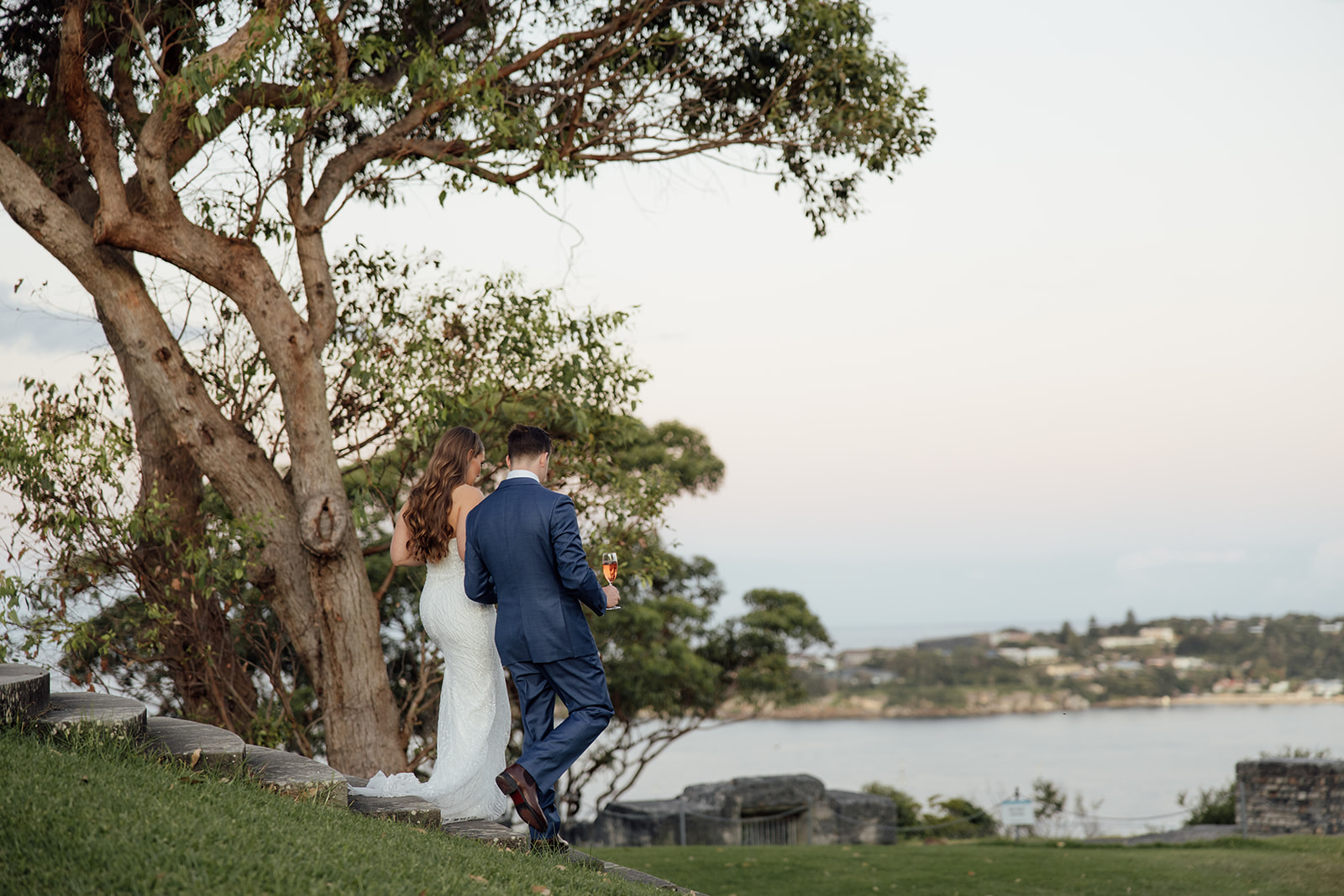 A bride and groom walking with ocean views