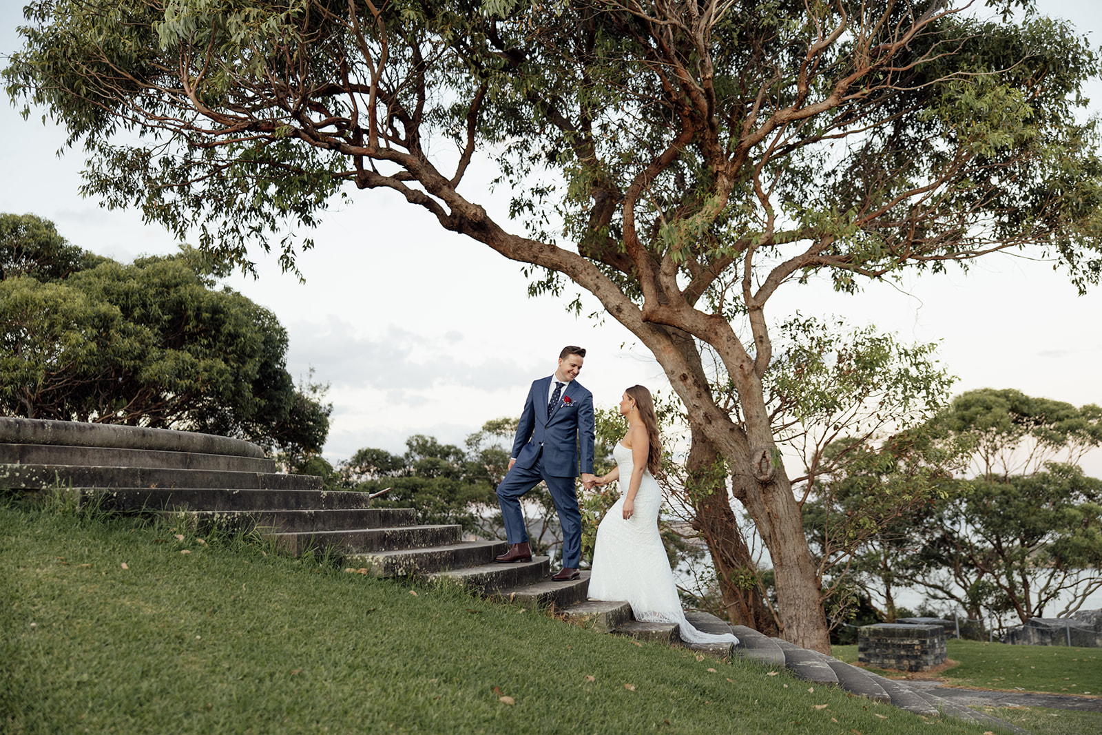 A bride and groom walking up stairs outdoors