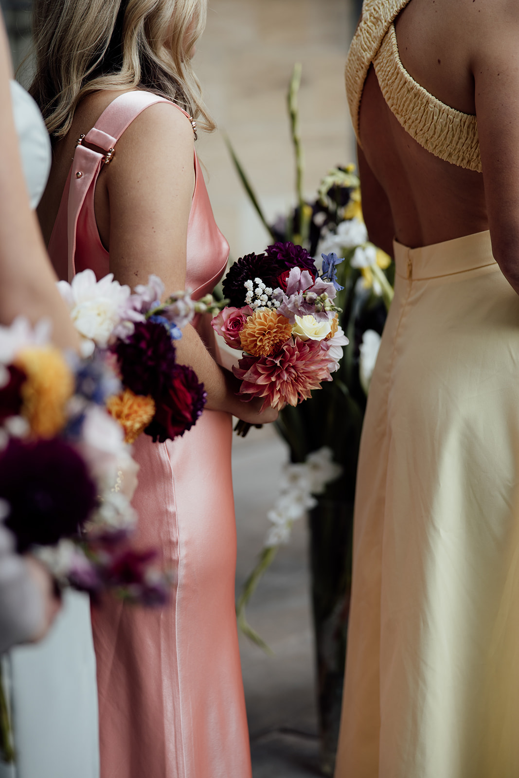 bridesmaids wearing colourful dresses holding bouquets 