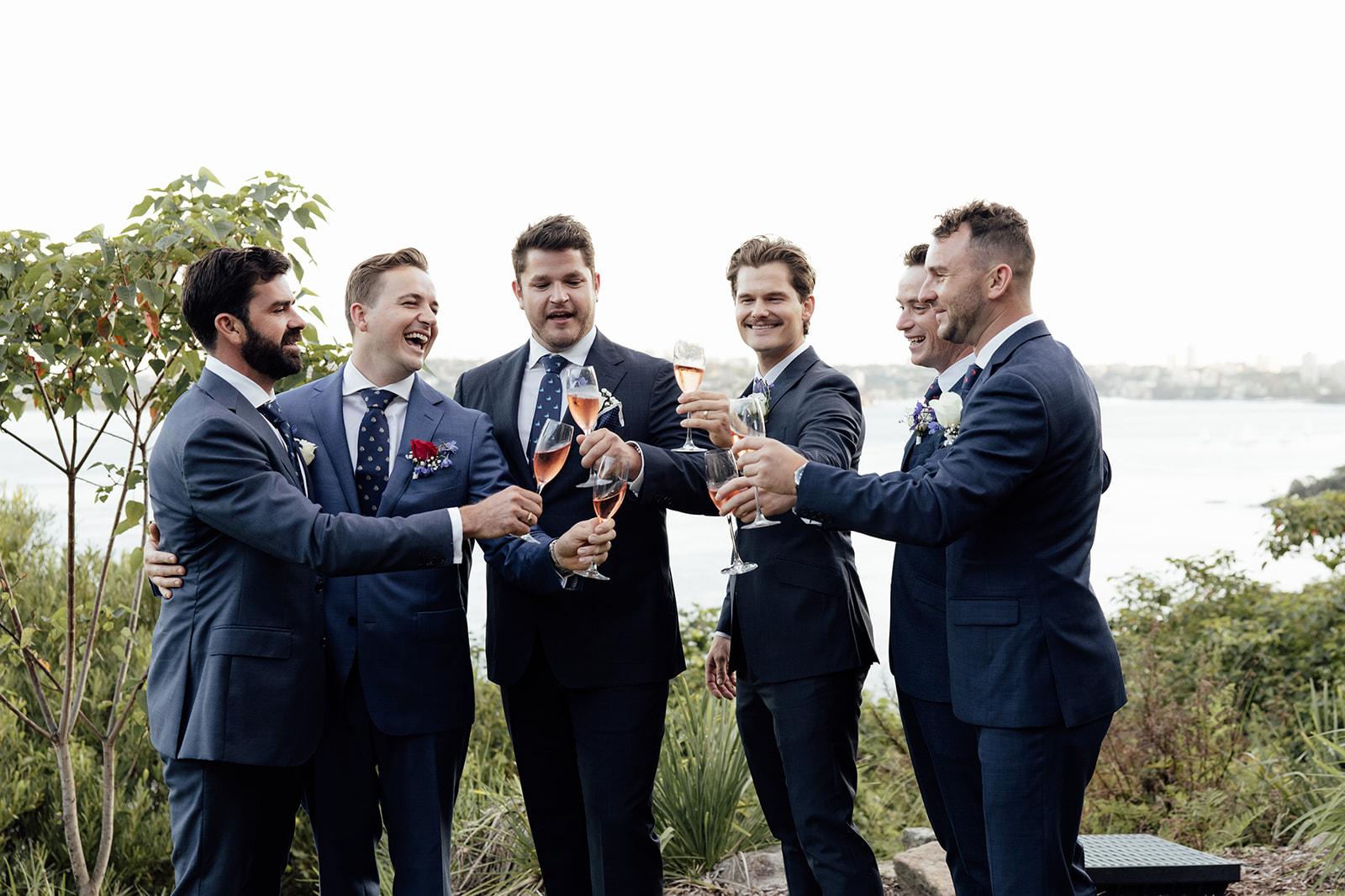 groom and groomsmen in suits celebrating