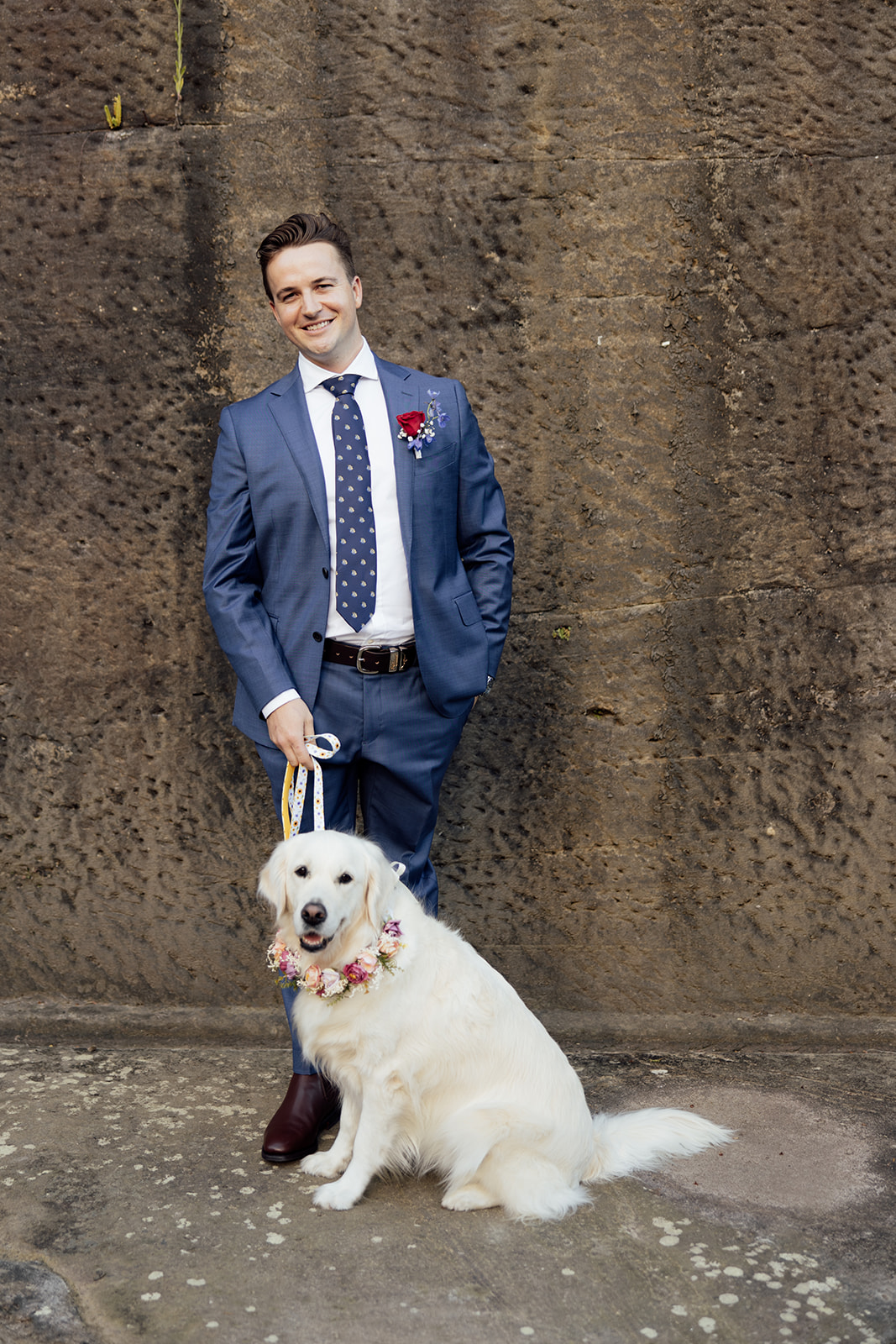 A man in a suit with a golden retriever dog