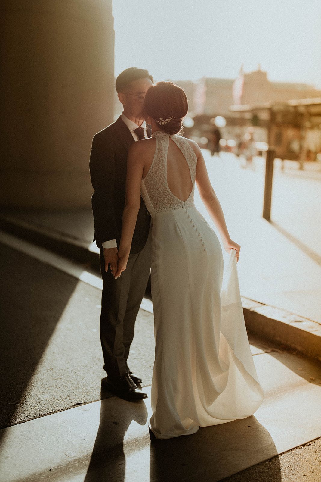afternoon photograph of the bride and groom with the sun shining behind them, creating a lens flare
