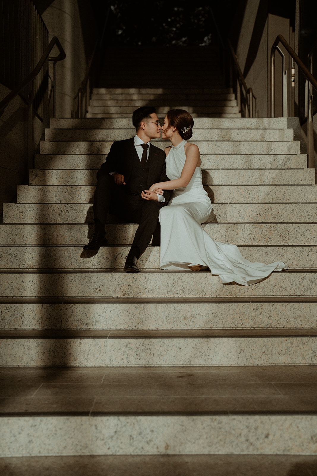 Bride and groom, kissing on steps