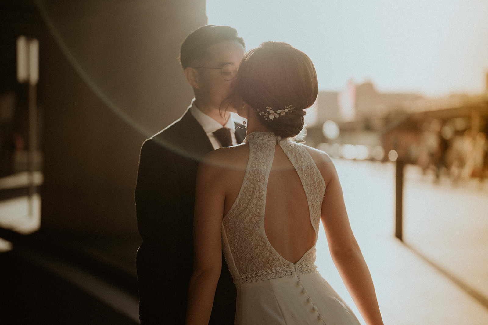 A very romantic photo of the sun behind the bride and groom, creating a lens flare